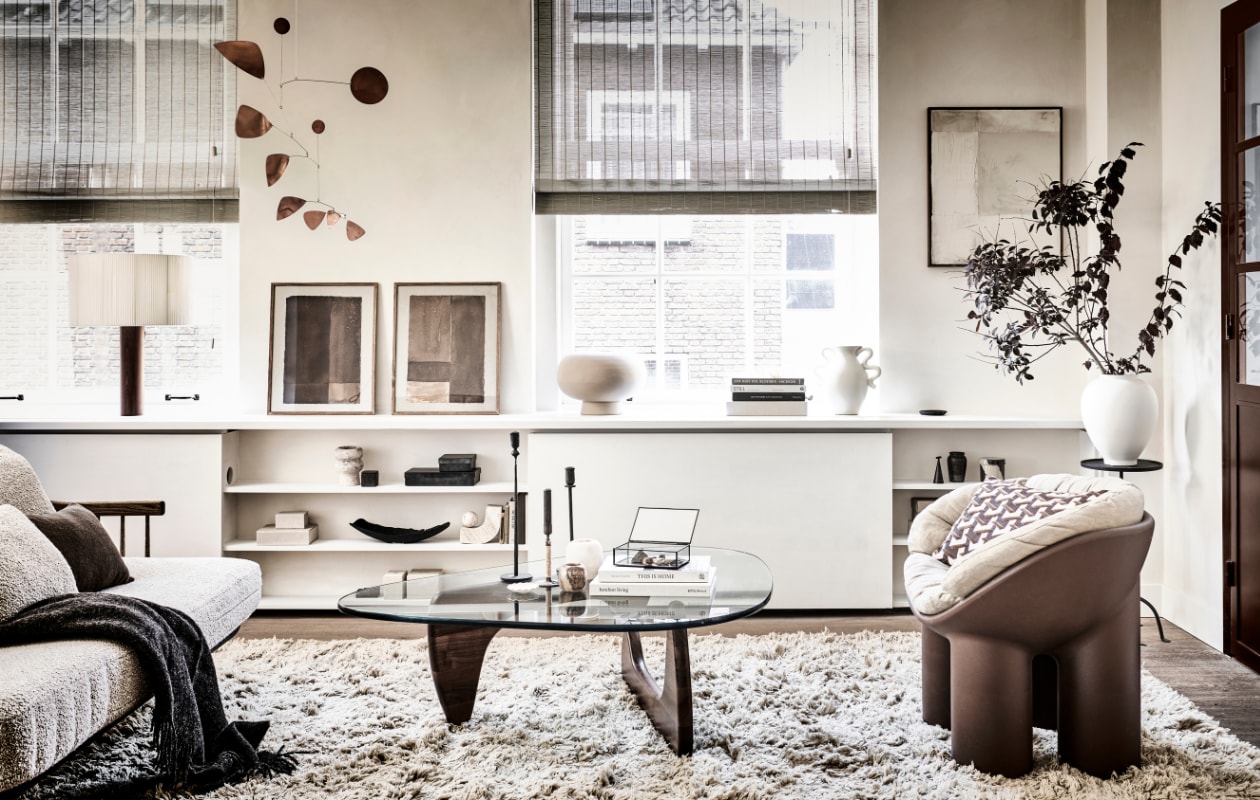Muurverf Lime Paint in de kleur Mykonos van Bauwerk (bauwerkcolour.com). Bank FlySC2 in Smoked Oiled Oak € 5495,- (andtradition.com). Wollen vloerkleed Meadow Lvan Ferm Living, 300x200 cm € 922,99, voorraadpot Inlay van Ferm Living large €33,99, small 30,99, crèmekleurige vaas met gekronkelde handvaten Verso van FermLiving € 75,- (vtwonen.nl). Koperen mobile Lappalainen € 310,- (pantoufle-design.nl).Bruine stoel The Roly Poly Chair van Driade € 495,-, beige linnen stoelkussen € 430,-,boek Barefoot Living € 75,- (casagitane.com). Glazen salontafel Noguchi metnotenhouten onderstel € 3310,-, tafellamp Moragas van Santa Cole € 1140,-(justhaasnoot.nl). Prints Art on Paper collectie n169 en n166 in lijst, 30x42 cm € 179,-,krijt op canvas schilderij Simplicity Crackle in lijst, 50x60 cm € 499,-(mooswillemsen.com). Kleine bruine vaas € 9,99, kleine platte zwarte schotel € 15,99,kleine witte schotel € 6,99, bruin wollen kussen, 30x50 cm € 39,99, vierkant bruinbakje met geurkaars € 9,99, kleine linnen opbergdoos klein € 12,99, groot € 29,99,metalen kegelvormige kaarsendover € 17,99, glazen opbergkistje € 19,99, rondemetalen plantentafel, 30x61x27 cm (bxhxl) € 79,99, ijzeren opbergkist met dekselvanaf € 17,99 (zarahome.com). Bruine wollen plaid, 130x170 cm € 69,99 (hm.com).Alabaster theelicht € 44,99 (sissy-boy.com). Travertin boekensteun Equi € 297,-,kussen in fauteuil Geometric bordeaux van HKliving € 49,95, beige bolvaas Kabin VaseFat € 149,- (loods5.nl/design). Messing kandelaar Duca omwikkeld met rotan van Menu€ 69,- (bymolle.com). Witte vaas, zwart schaal, boeken privébezit. vtwonen 11-2022 | styling Kim van Rossenberg | fotografie Sjoerd Eickmans |