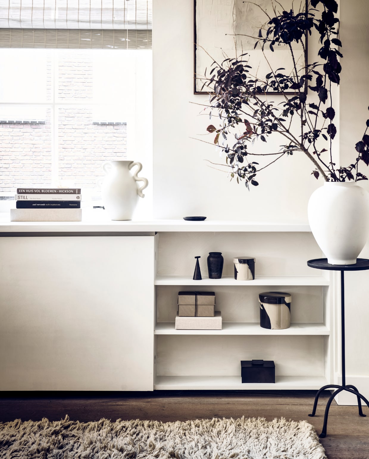Muurverf Lime Paint in de kleur Mykonos van Bauwerk (bauwerkcolour.com). Bank FlySC2 in Smoked Oiled Oak € 5495,- (andtradition.com). Wollen vloerkleed Meadow Lvan Ferm Living, 300x200 cm € 922,99, voorraadpot Inlay van Ferm Living large €33,99, small 30,99, crèmekleurige vaas met gekronkelde handvaten Verso van FermLiving € 75,- (vtwonen.nl). Koperen mobile Lappalainen € 310,- (pantoufle-design.nl).Bruine stoel The Roly Poly Chair van Driade € 495,-, beige linnen stoelkussen € 430,-,boek Barefoot Living € 75,- (casagitane.com). Glazen salontafel Noguchi metnotenhouten onderstel € 3310,-, tafellamp Moragas van Santa Cole € 1140,-(justhaasnoot.nl). Prints Art on Paper collectie n169 en n166 in lijst, 30x42 cm € 179,-,krijt op canvas schilderij Simplicity Crackle in lijst, 50x60 cm € 499,-(mooswillemsen.com). Kleine bruine vaas € 9,99, kleine platte zwarte schotel € 15,99,kleine witte schotel € 6,99, bruin wollen kussen, 30x50 cm € 39,99, vierkant bruinbakje met geurkaars € 9,99, kleine linnen opbergdoos klein € 12,99, groot € 29,99,metalen kegelvormige kaarsendover € 17,99, glazen opbergkistje € 19,99, rondemetalen plantentafel, 30x61x27 cm (bxhxl) € 79,99, ijzeren opbergkist met dekselvanaf € 17,99 (zarahome.com). Bruine wollen plaid, 130x170 cm € 69,99 (hm.com).Alabaster theelicht € 44,99 (sissy-boy.com). Travertin boekensteun Equi € 297,-,kussen in fauteuil Geometric bordeaux van HKliving € 49,95, beige bolvaas Kabin VaseFat € 149,- (loods5.nl/design). Messing kandelaar Duca omwikkeld met rotan van Menu€ 69,- (bymolle.com). Witte vaas, zwart schaal, boeken privébezit. vtwonen 11-2022 | fotografie Sjoerd Eickmans | styling Kim van Rossenberg | uitvoering Richard van Meerveld