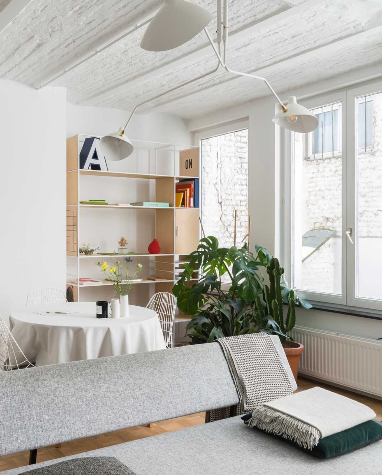 Kussen van Hay, plaid van By Mölle, poster van SB Studio, plant van Green Lifestyle store, stoel van Pastoe, boekenkast van Zuiver, vaas van Menu, spiegel van Kartell, kapstok van pt, zetel van Zuiver. vtwonen 12-2017 | styling &amp; fotografie Jonah Samyn | tekst Katrien Depoorter