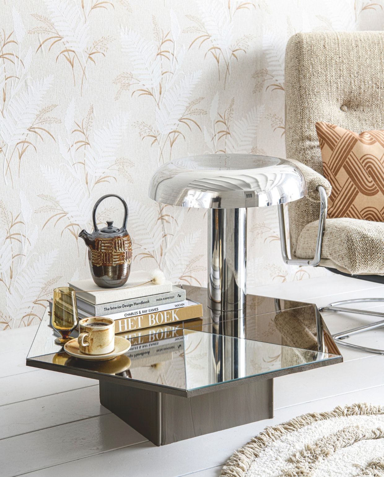 Glas € 9,50 (zaanschfaamwebshop.nl). Keramieken theepot € 99,95 (lydiaelisabethpottery.nl). Chromen tafellamp Lounge van HKliving, 47x49 cm (Øxh) € 316,- (flinders.nl). Vloerkleed, 80 cm (Ø) € 21,21, porseleinen kop-en-schotel Chef Ceramics van HKliving € 12,71, kussen Heyday van HKliving € 23,75 (deens.nl). Vintage behang 13174, jutelook met varens € 55,- (swiet.nl). Vintage fauteuil van Jan des Bouvrie voor Gelderland (marktplaats.nl). vtwonen 09-2024 | styling Myla Griese | fotografie Louis Lemaire