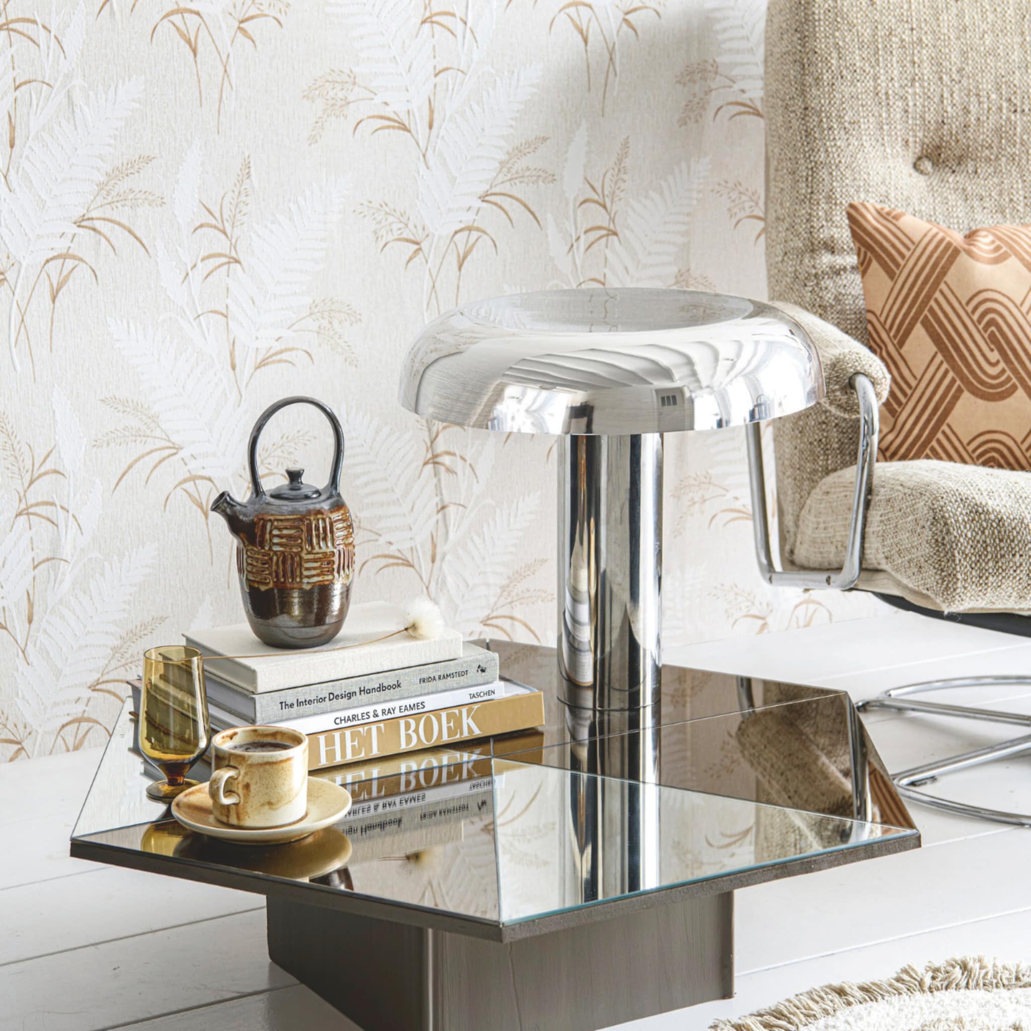 Spiegeltafel met een glanzende tafellamp, koffietafelboeken en goud servies
