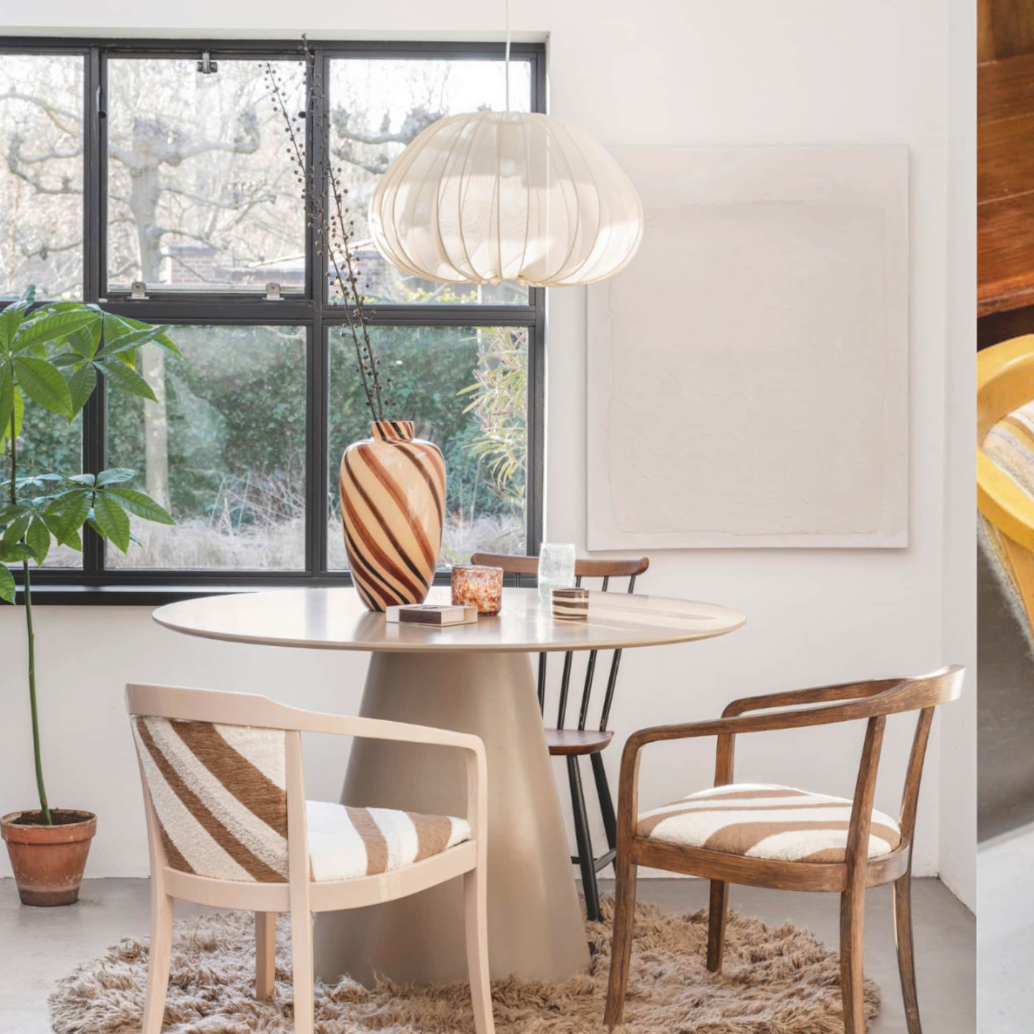 Naturel eetkamerstoelen bij een moderne ronde eettafel