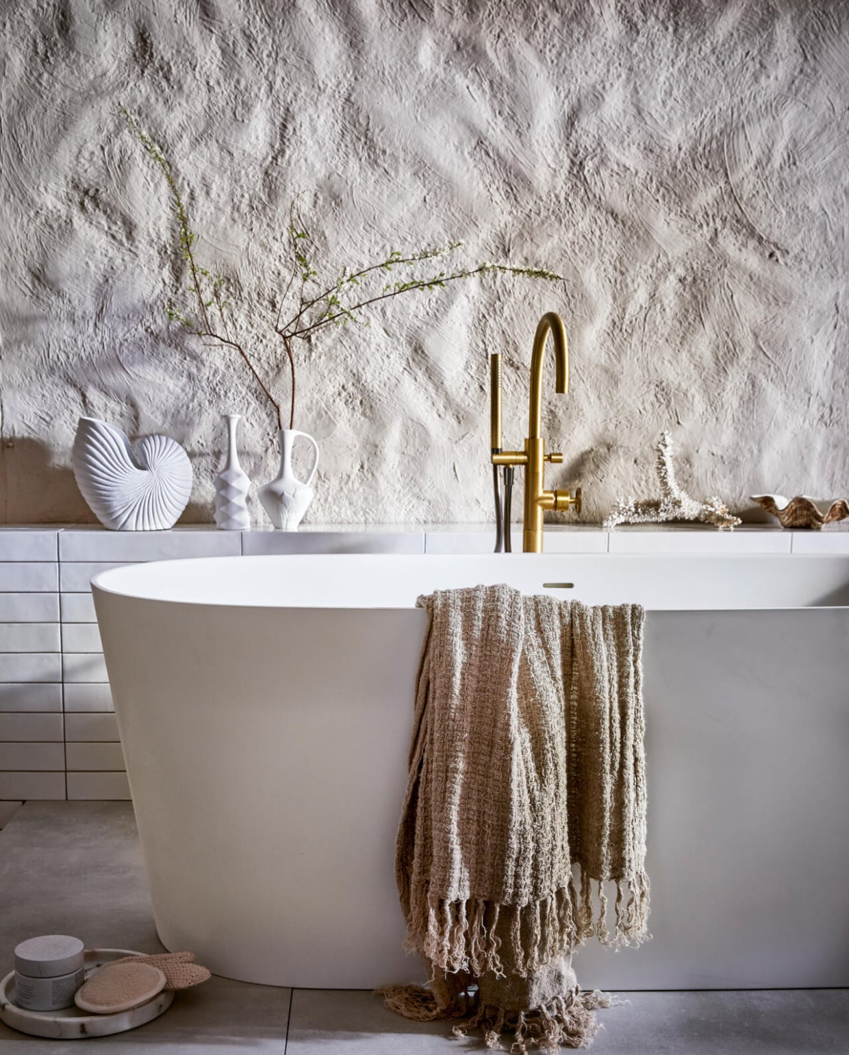 Wandtegel Marrakesh, kleur Nieve, glans, 6,5x40 cm, per m² € 62,35. Bad Tub € 3163,-. Badmengkraan Flame, kleur Bronze, vrijstaand € 2353,-. Vloertegel Mold XL Cement, 90x90 cm, per m² € 71,10.M.m.v. hkliving.nl (witte vaas). vtwonen 08-2021 | productie Tanja Saarberg | styling Cleo Scheulderman | fotografie Jeroen van der Spek
