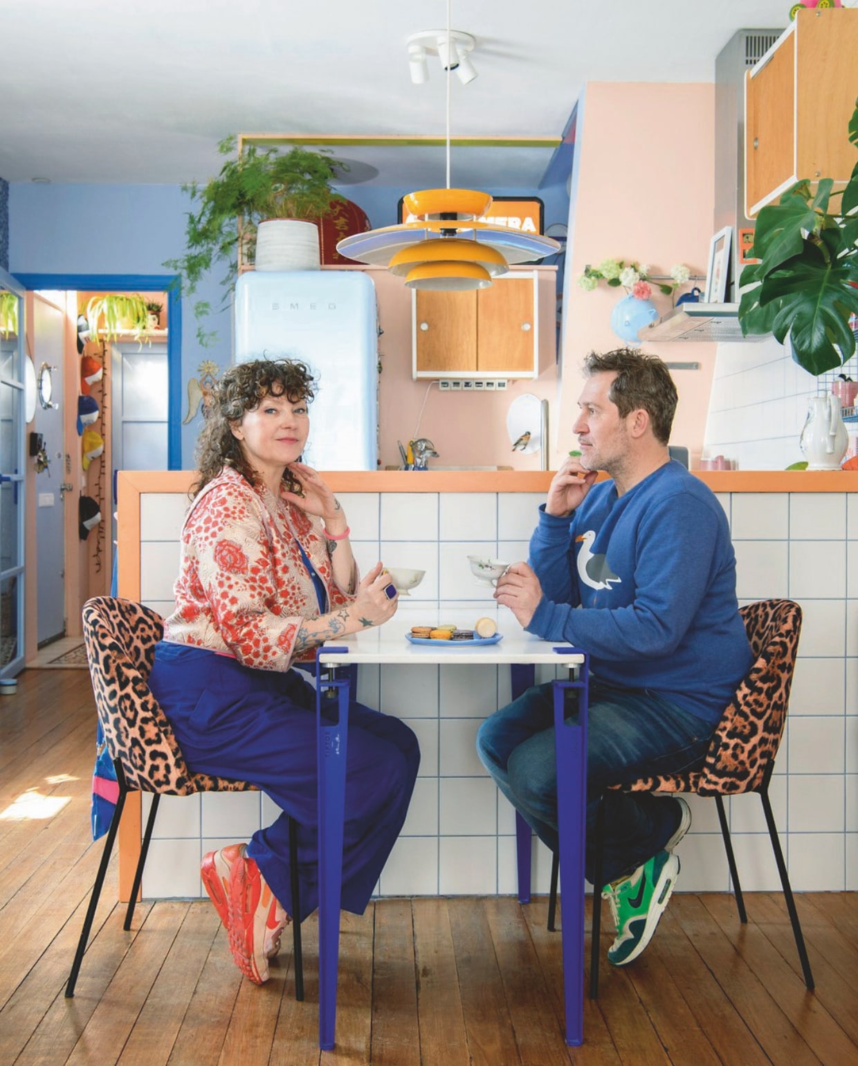 Koelkast Smeg, tafelpoten van Tiptoe via Hoeked, tafelblad zelfgemaakt, hanglamp Vintage Asylum, tegels Wout’s Tegelhandel, wandkasten Marktplaats, oranje lichtbak uit tweedehandswinkel in Porto. Houten vloer lag al in het huis. Muurverf Perzik en Retro Blauw van Decoverf. Verf deurkozijn Middenblauw van Decoverf. vtwonen 09-2024 | styling Inge van Lieshout | fotografie Louis Lemaire