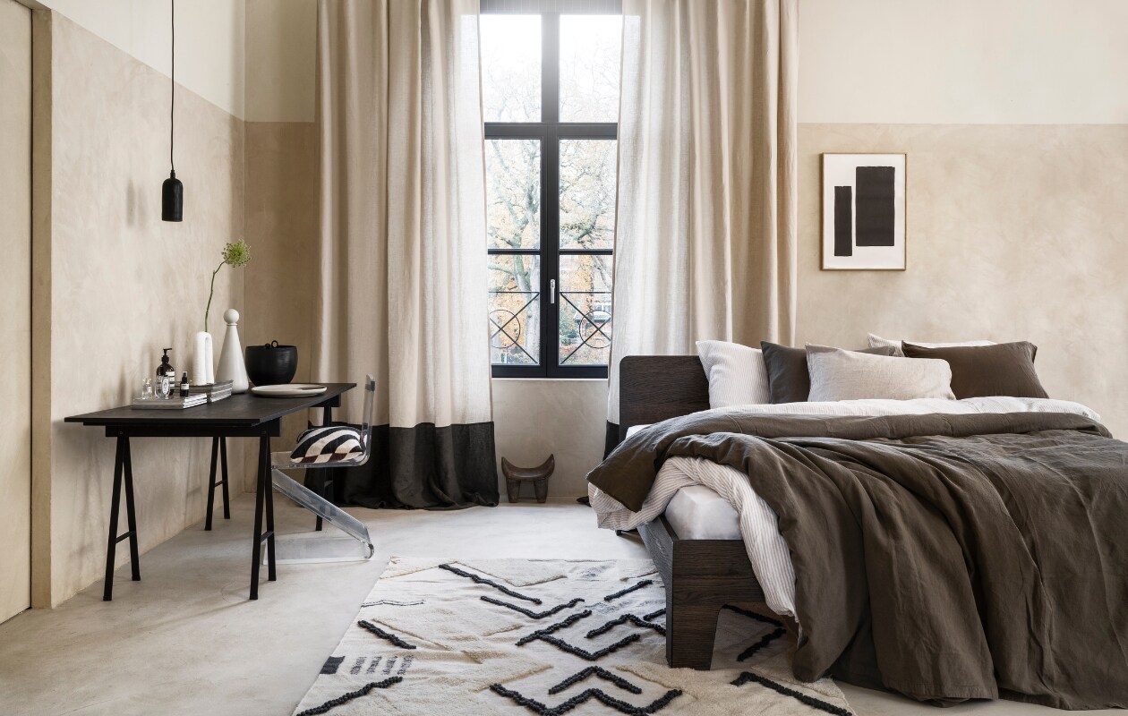 Stucco-look muurverf Mykonos, 2,5 liter € 110,- (wearewowmakers.com). Gordijn gemaakt van linnen Cloud Rider van Chivasso, per meter € 114,50 (jab.de). Bedombouw Pure, eiken fineer in Charcoal olie, 180x200 cm (bxd) € 3400,- (Loof). Duurzaam gewassen linnen dekbed-overtrekset met smalle strepen, 240x220 cm € 329,- (yumeko.be). Bruine dekbedovertrekset, duurzaam linnen en katoen, 240x220 cm € 179,95 (suite702.com). Vloerkleed, 260x160 cm € 399,- (malagoon.com). Tafel van Serax, 150x75x73cm (lxbxh) € 824,-, vaas met bolvormig deksel van Ferm Living € 85,-, schaal Omhu van Ferm Living € 105,- (flinders.be). Vintage transparante zigzagstoel € 350,- (Neef Louis). Hanglamp € 79,95, pot met oor € 62,95 (urbannatureculture.com). Vaas met twee poten van vtwonen € 49,95, gestreept kussen van Oyoy € 54,99 (vtwonen.be). Poster met lijst vanaf € 95,- (loods5.com). Afrikaans krukje privébezit. vtwonen 03-2023 | styling Marianne Luning | fotografie Stan Koolen