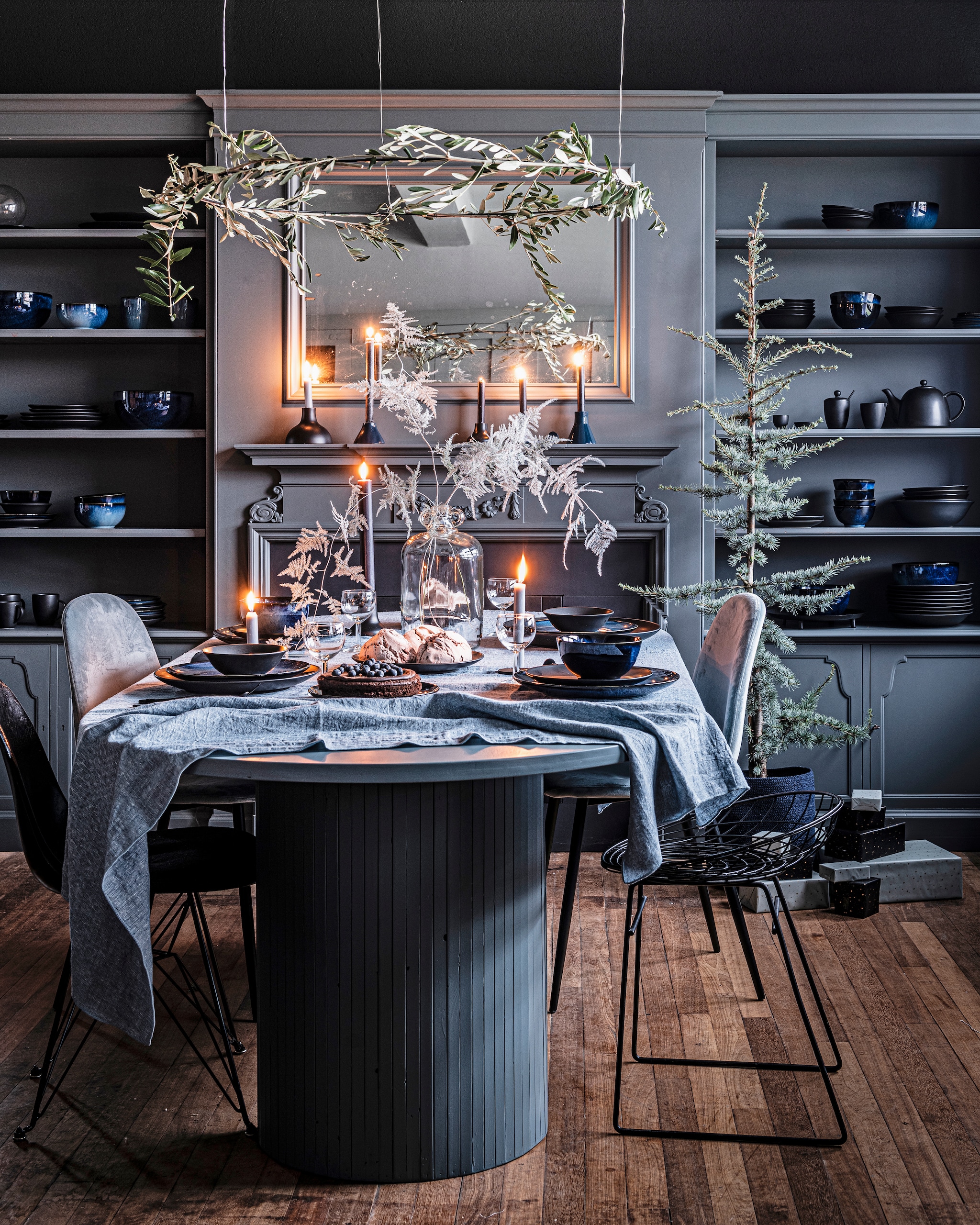 Donkerblauw porseleinen servies, 16-delig € 99,-, ook verkrijgbaar als losse onderdelen vanaf € 3,95. Matblauw porseleinen servies, 16-delig € 99,- of 36-delig € 239,-, ook verkrijgbaar als losse onderdelen vanaf € 4,50. Matzwart porseleinen servies 16-delig € 99,- of 36-delig € 239,-, ook verkrijgbaar als losse onderdelen vanaf € 1,95. Diverse metalen kandelaars zwart en donkerblauw vanaf € 8,95. Glazen vaas 22×31 cm (Øxh) € 69,95. Linnen tafelkleed, 150×250 cm (bxl) € 79,95. Zwarte ornamenten ring 100 cm (Ø) € 24,95, ook in formaat 80 cm (Ø) € 19,95. vtwonen 12-2021 | productie Tanja Saarberg | styling Kim van Rossenberg | fotografie Sjoerd Eickman