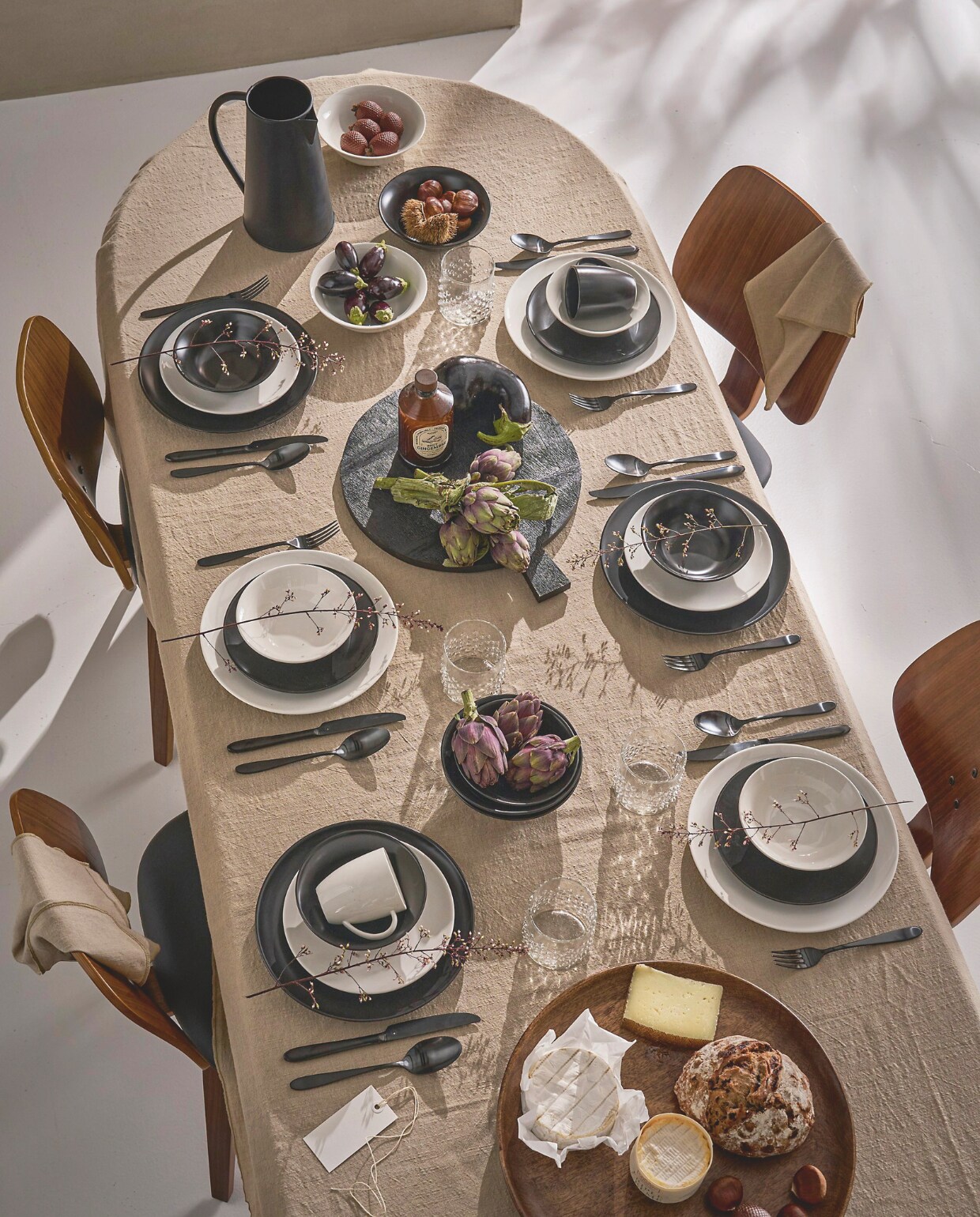 Porseleinen serviesset in wit, 36-delig € 225,-. Porseleinen serviesset in matzwart , 16-delig € 109,-. Inhoud van beide sets, resp. 6 en 4 keer borden 20 cm (Ø), borden 25,5 cm (Ø), kommen 15 cm (Ø) en mokken met oor 250 ml. Bij de witte set ook 6 pastaborden 25,5 cm (Ø) en 6 kommen 18 cm (Ø). Witte set ook verkrijgbaar met koffiemokken met schotels. Metalen bestekset in matzwart, 18-delig, € 89,-. Metalen kan met handvat, 10/15x23 cm (Øxh) € 24,95. Tafelkleed in naturel, katoen en linnen, 150x250 cm € 69,95. Mangohouten bord maat L, 40,5 cm (Ø) € 69,95. Zwarte mangohouten serveerplank met handvat, 42x35x1,5 cm € 49,95. Waterglas met stippen, 300 ml € 6,95. Servetten in naturel, katoen en linnen, 40x40 cm, set van 2 € 9,95. Eetkamerstoel Classic in bruin en zwart, walnoothout en kunstleer, 50x48x81 cm (bxdxh) € 149,-. vtwonen 10-2024 | styling Cleo Scheulderman | fotografie Jeroen van der Spek