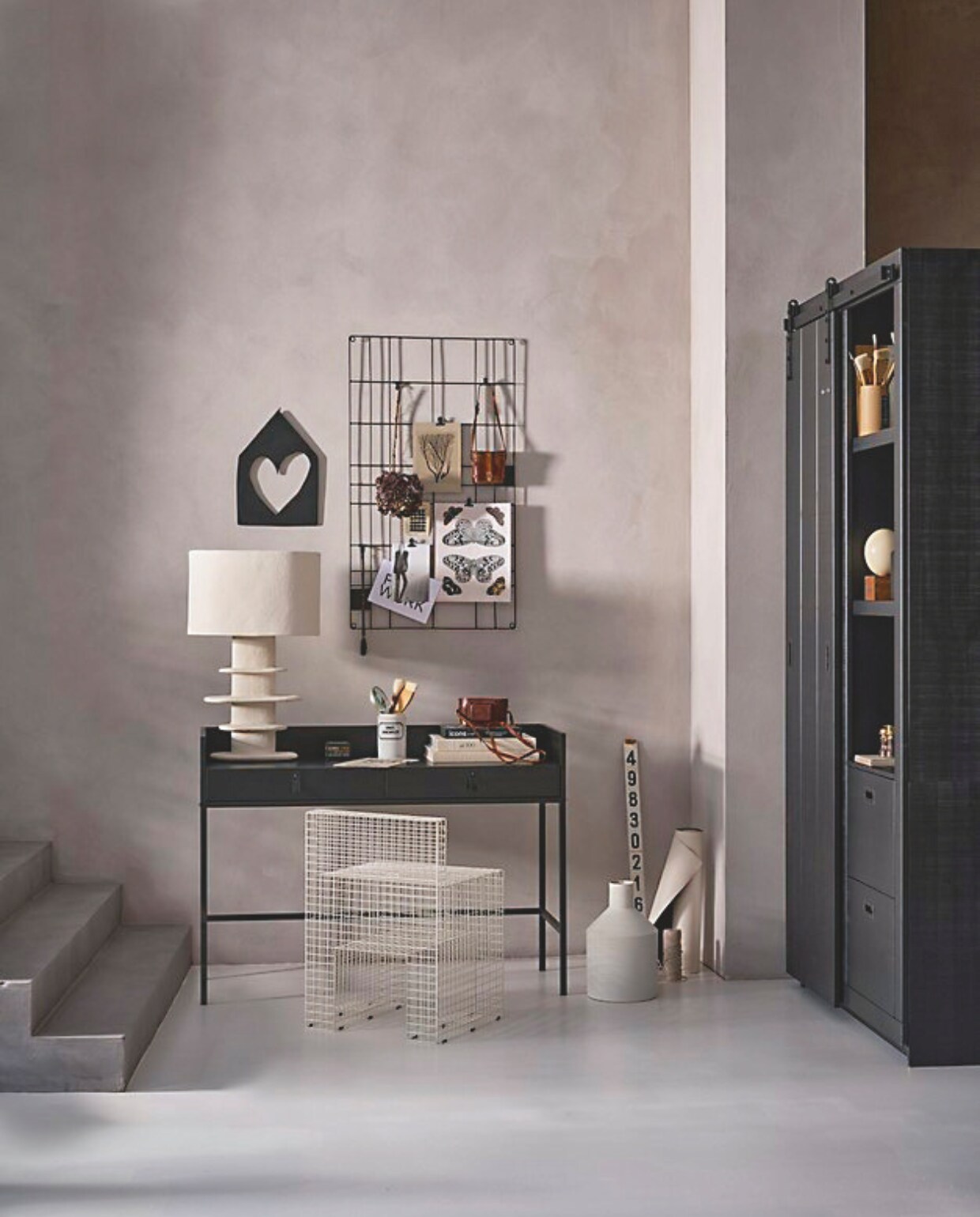 Notenhouten bureau/sidetable Bookazine in zwart, 120x44x87 cm (bxdxh) € 299,-. Metalen memobord, 60x105 cm (bxh) € 39,95. Houten muurornament huisje met hart , 29x41,5 cm (bxh) € 24,95. Grenenhouten kast Slide in zwart, 122x37x230 cm (bxdxh) € 1059,-. Metalen vaas, 24x38 cm (Øxh) € 59,95. M.m.v. thefarm-shop.nl (verf muur Bold Basalt, verf trap Consious Concrete), vtwonen.nl/shop (tafellamp Earth van Serax), vandijkenko.nl (witte porseleinen pot met etiket), bol.com (struisvogelei), vanbeekart.nl (penselen). Overig privébezit. vtwonen 10-2024 | styling Cleo Scheulderman | fotografie Jeroen van der Spek
