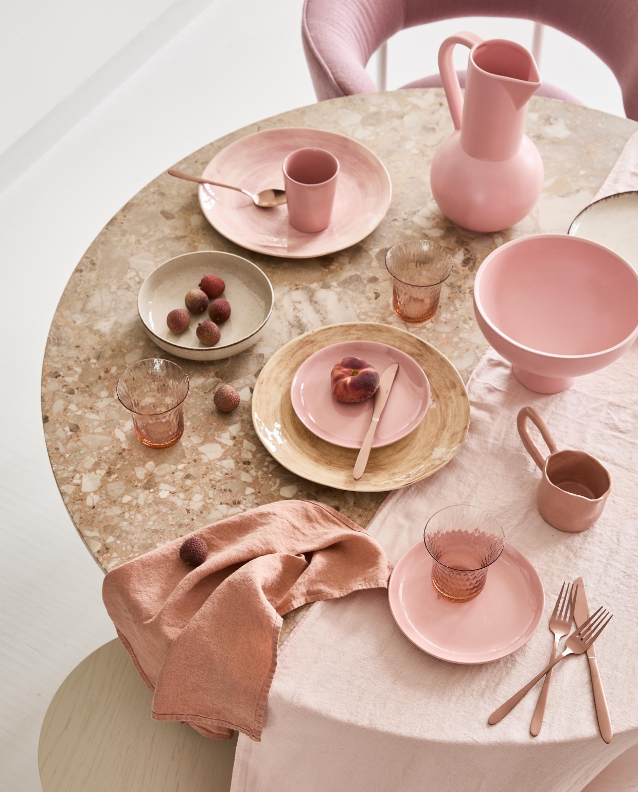 Eettafel Androgy van Menu in Dark stained oak/sand, 120×73 cm € 2786,70, koperkleurig bestek Ona Slim, 24-delig € 44,99, theekop Feast van Serax in Delicious Pink, 0,33 liter € 13,40, bord Feast van Serax in Delicious Pink, 19 cm (Ø) € 15,70 (vtwonen.nl). Linnen tafelkleed,160×350 cm € 179,-, servet € 12,-, roze en bruin bord van Wonki Ware, 30 cm (Ø) € 34,- (couleurlocale.eu). Roze kan van Raawii € 90,-, schaal op voet van Raawii € 70,-, beker met lang oor van Siup Studio € 14,95 (groenenakker.nl). Roze glazen € 6,99 en diep bord € 7,99 (zarahome.com). Roze stoel de Font Regular Dining Chair van Møbel-Copenhagen vanaf € 1131,- (roosdesign.eu) vtwonen 04-2022 | styling Cleo Scheulderman | fotografie Jeroen van der Spek | assistentie Krystel-Jane Robinson, Jamaine Festen