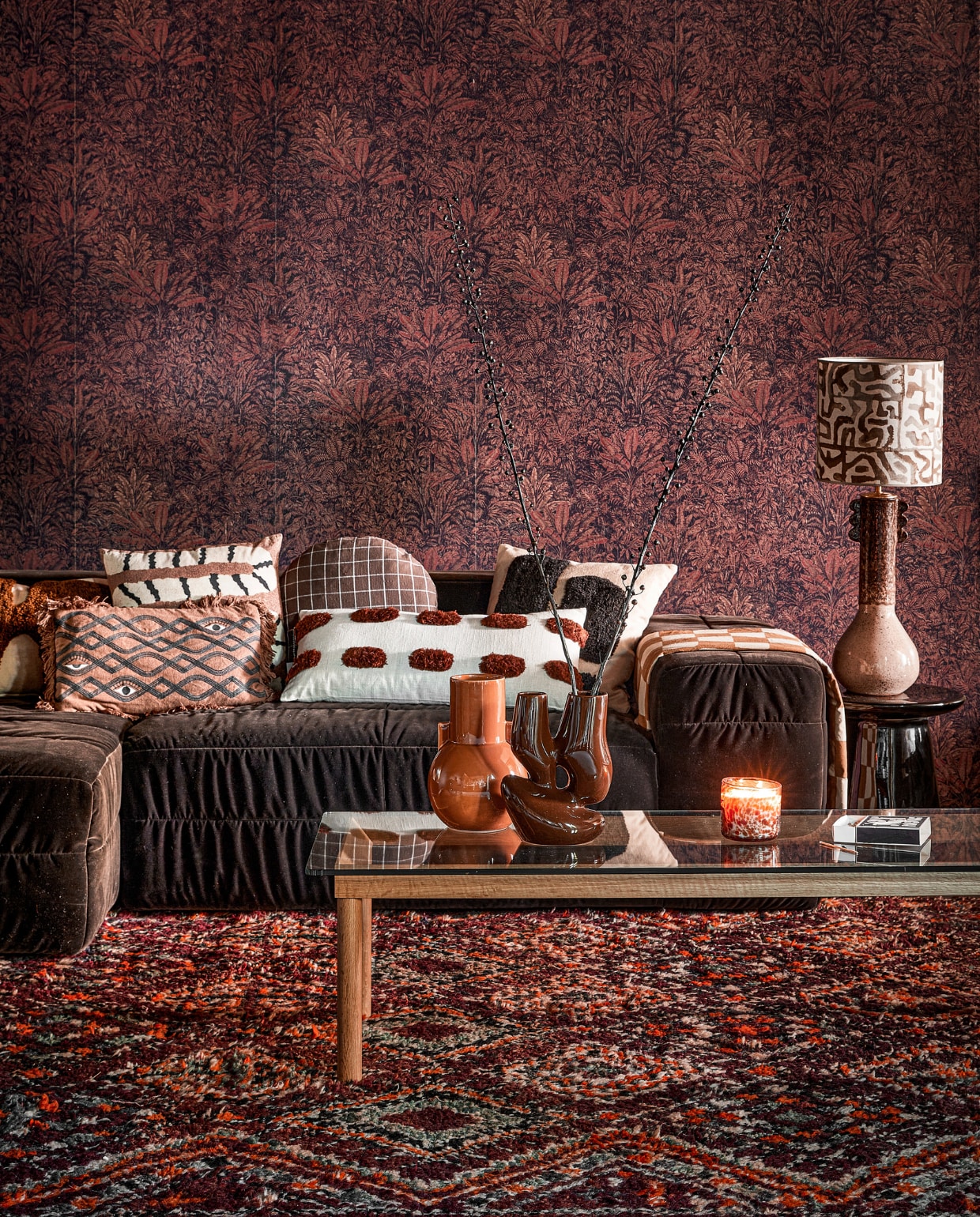Vliesbehang Sauvage Burgundy, 53x100,5 cm (bxl), per rol € 125,- (masureel.com). Polyester bank Brut in Espresso, 308x105x71 cm (bxdxh) € 3290,- (hkliving.com). Wollen vloerkleed Beni Mguild 31380, 396x213 cm € 1190,- (rozenkelim.nl). Salontafel Kofi, hout en glas € 689,- (hay.dk). Tafellamp, keramiek en linnen € 525,- (madamgarage.nl). Links vooraan katoenen kussen Galia van Bloomingville € 59,90, erachter katoenen kussen Africa van vtwonen € 39,95, rond katoenen kussen Kyoto van Oyoy € 54,99, katoenen kussen met grof geborduurde steek van vtwonen € 49,95, kussen Lay van Ferm Living, katoen en wol € 79,-, keramieken bijzettafel Earthenware van HKliving € 279,-, aardewerken vaas Ceramic van HKliving € 49,95, keramieken vaas Organic van HKliving € 59,95 (vtwonen.nl/shop). Overig privébezit. vtwonen 10-2023 | styling Kelly van Gendt | fotografie Peggy Janssen