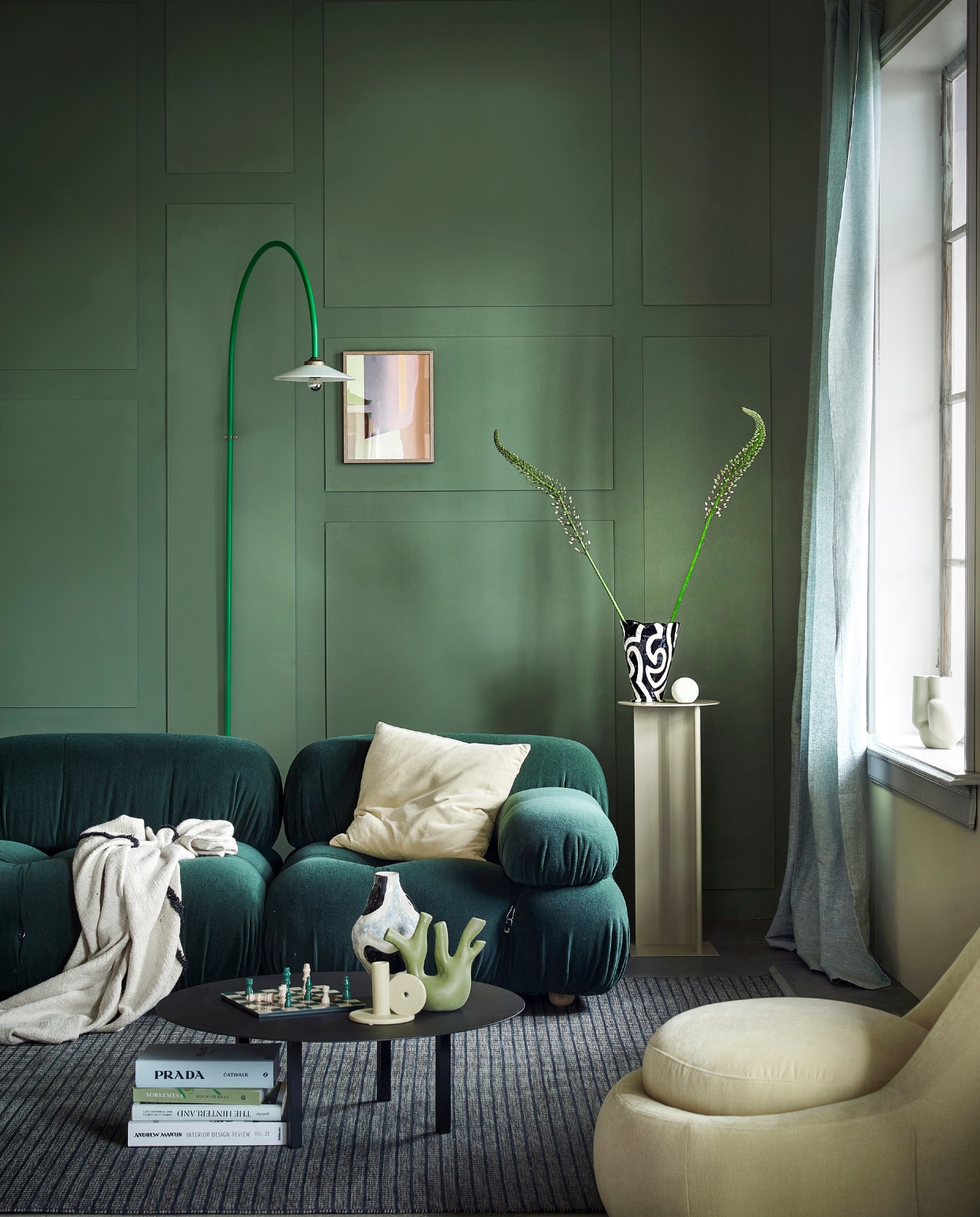 Muurverf links Card Room Green No.79, per 2,5 liter € 97,- (farrow-ball.com), rechts Farrow’s Cream No.67 van Farrow & Ball, per 2,5 liter  € 97,- (paint-paper.nl). Bank Camaleonda van B&B Italia, prijs op aanvraag, vloerkleed Post Icon in Evening Blue 586 van Kasthall Design Studio, 250x350 cm prijs op aanvraag, wandlamp Hanging Lamp No 2 in Green van Valerie Objects € 772,- (justhaasnoot.nl). Polyester fauteuil Babette in Danny Cream  € 569,- (sofacompany.com). Stalen pilaar Pedestal Place in Cashmere van Ferm Living, 31x75 cm (Øxh) € 339,-, metalen salontafel 02 van Serax, 78x25 cm (Øxh) € 450,-, groen ecomix ornament Tree van Urban Nature Culture  € 39,95 (vtwonen.nl). Ingelijste papiercollage Nude, 28x35 cm € 145,- (femm.amsterdam). Getuft plaid, 130x170 cm € 74,95 (hkliving.com). Zwart-witte aardewerken vaas Jessica Hans Shadow € 79,-, lichtgele vaas Chubby van  Wang & Söderström € 85,-, kussen Outline, 50x50 cm € 75,- (hay.nl). Gele kandelaar  € 14,99, schaakspel € 49,99 (hm.com). Gordijnen Lenda, 140x300 cm, set van 2  € 29,99 (ikea.nl). Overig privébezit. vtwonen 10-2022 | styling Kim van Rossenberg | fotografie Peggy Janssen