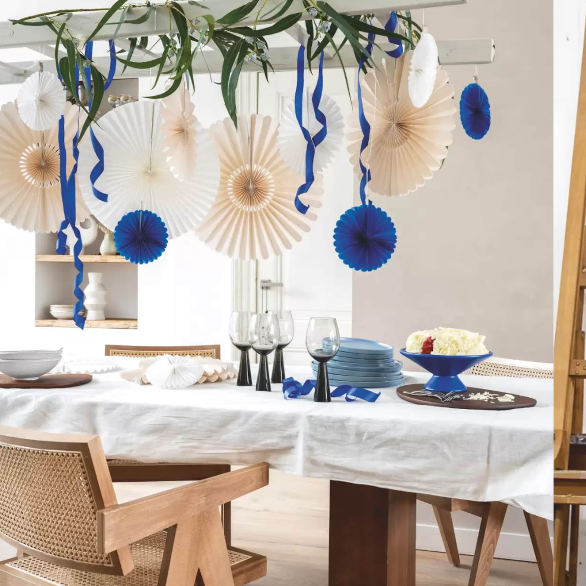 Feestelijk gedekte eettafel met servies en versiering in creme en blauw