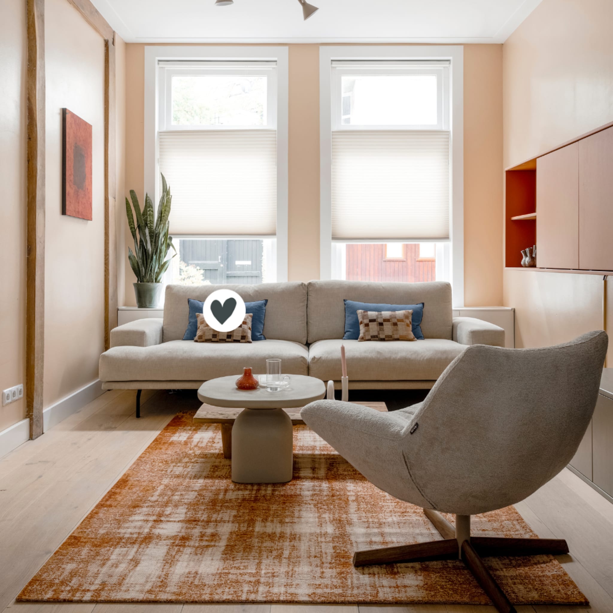 Naturel woonkamer met een grijze bank en een oranje vloerkleed