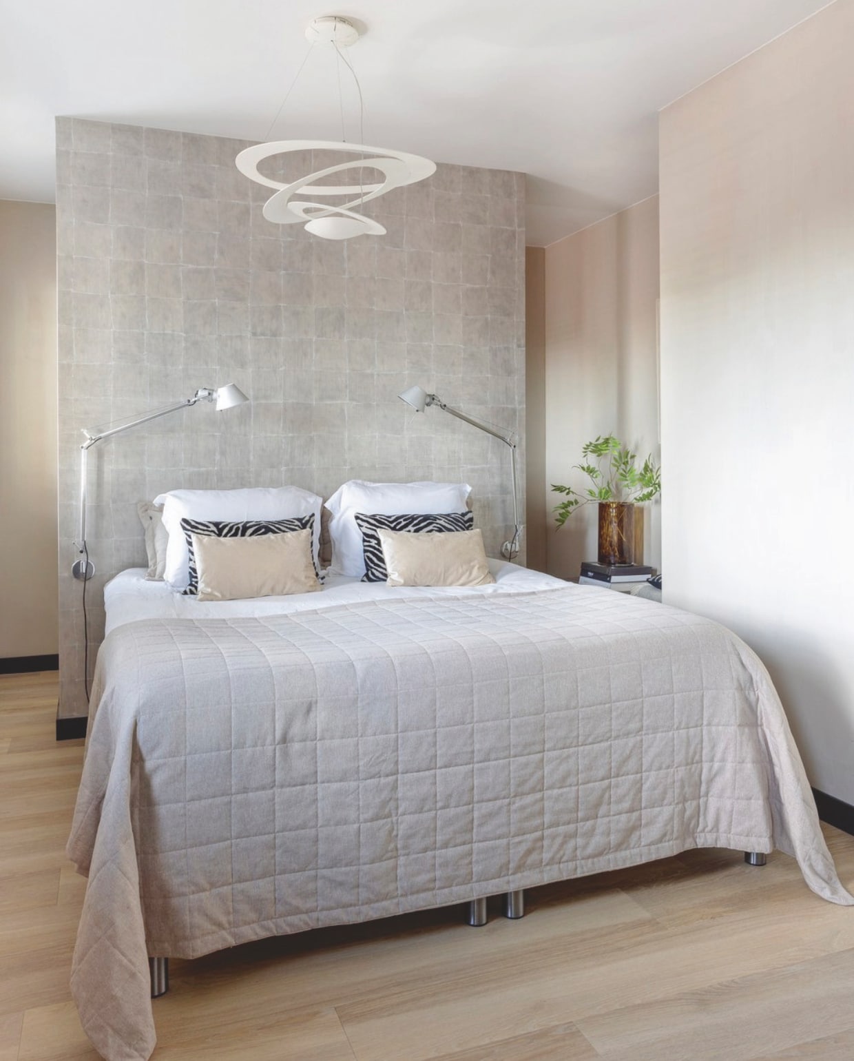 Het beddengoed is van Coco &amp; Cici, de sprei van Jotex. Net als een aantal sierkussens, andere zijn van Claudi. Naast het bed staan lampen Tolomeo, die net als hanglamp Pirce van Artemide zijn. Op de achterwand is gekozen voor behang Paradisio van Élitis. stijlvol wonen 09-2024 | fotografie Anneke Gambon