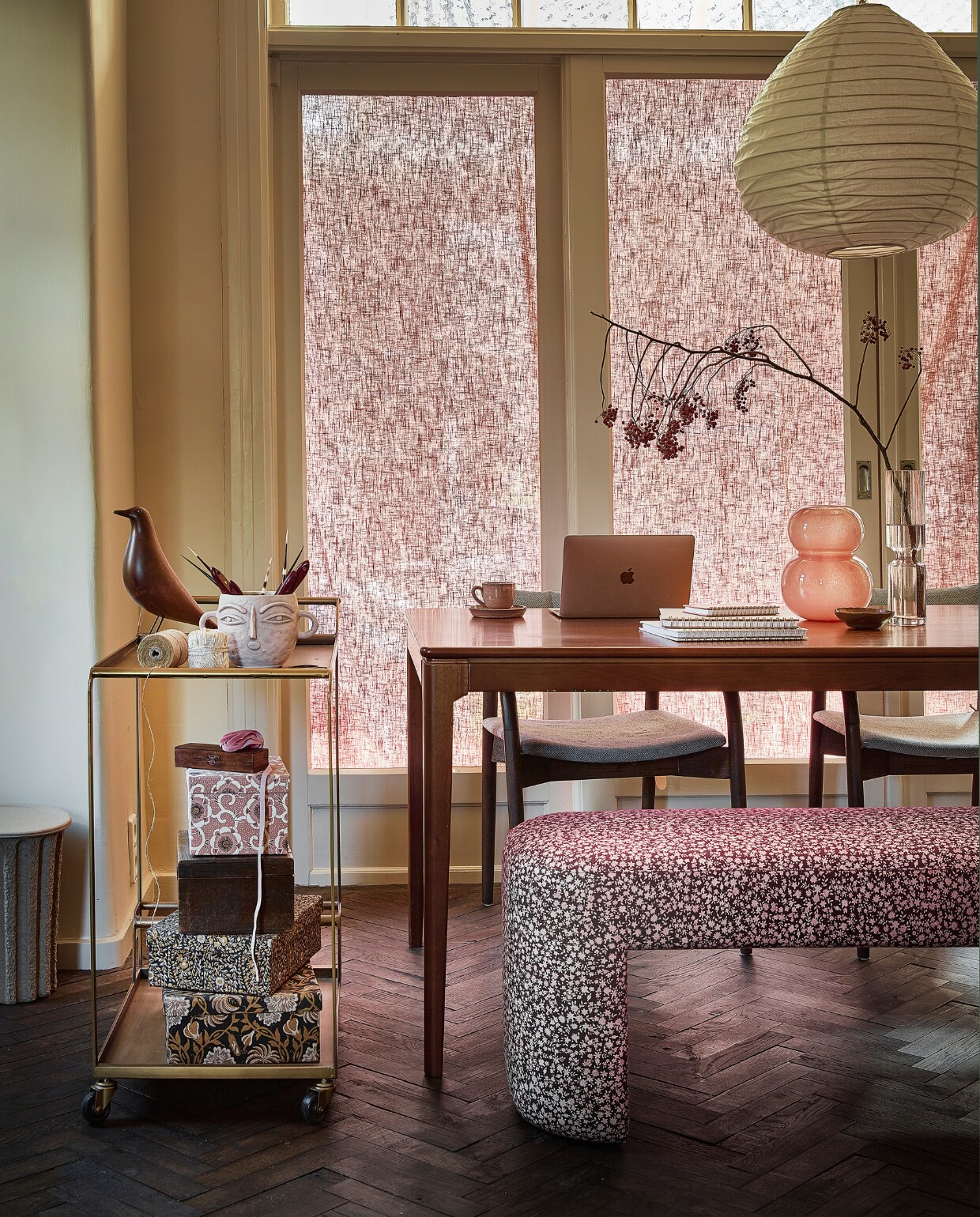 Linnen raambekleding Loes 2421 Marsala, per meter € 27,99 (karwei.nl). Stoffen hanglamp, 50x50x45 cm (bxdxh) € 95,-, langwerpige vaas met bruin glas € 39,95 (stijldepot73.nl). Papierpulp prullenbak van Ferm Living, 28x28x35,5 cm (bxdxh) € 45,-, object vogel van Vitra € 199,-, walnoothouten eetkamertafel Merijn van Loods 5 Goods, 180x90x75 cm (bxdxh) € 595,- (loods5.nl). Lichtroze vaas met gezicht € 37,87 (nordal.com). Messing trolley, 74x4x82 cm (bxdxh) € 179,- (kieveen.nl). Houten doosje € 11,50, keramieken kop-en-schotel, per 6 € 30,-, koperen schaaltje € 9,50 (@flowerchild.arnhem). Roze papieren doos met bloemen € 20,-, papieren doos met bloemen en papieren doos met print € 48,75 (bungalow.dk). Houten kist € 20,- (johnsbrocante.nl). Eetkamerstoel Torrance van Dutchbone, rubberhout en polyester € 299,-, glazen oranje-roze vaas Lasi van Oyoy € 83,-, gebloemde eetkamerbank van HKliving, 140x40x45 cm (bxdxh) € 495,-(vtwonen.nl). Notitieboeken vanaf € 9,95 (vita32.nl). Tak rode bessen € 8,50 (natuurlijkeerbeek.nl). Overig privébezit. vtwonen 10-2022 | styling Demelza Krens | fotografie Peggy Janssen