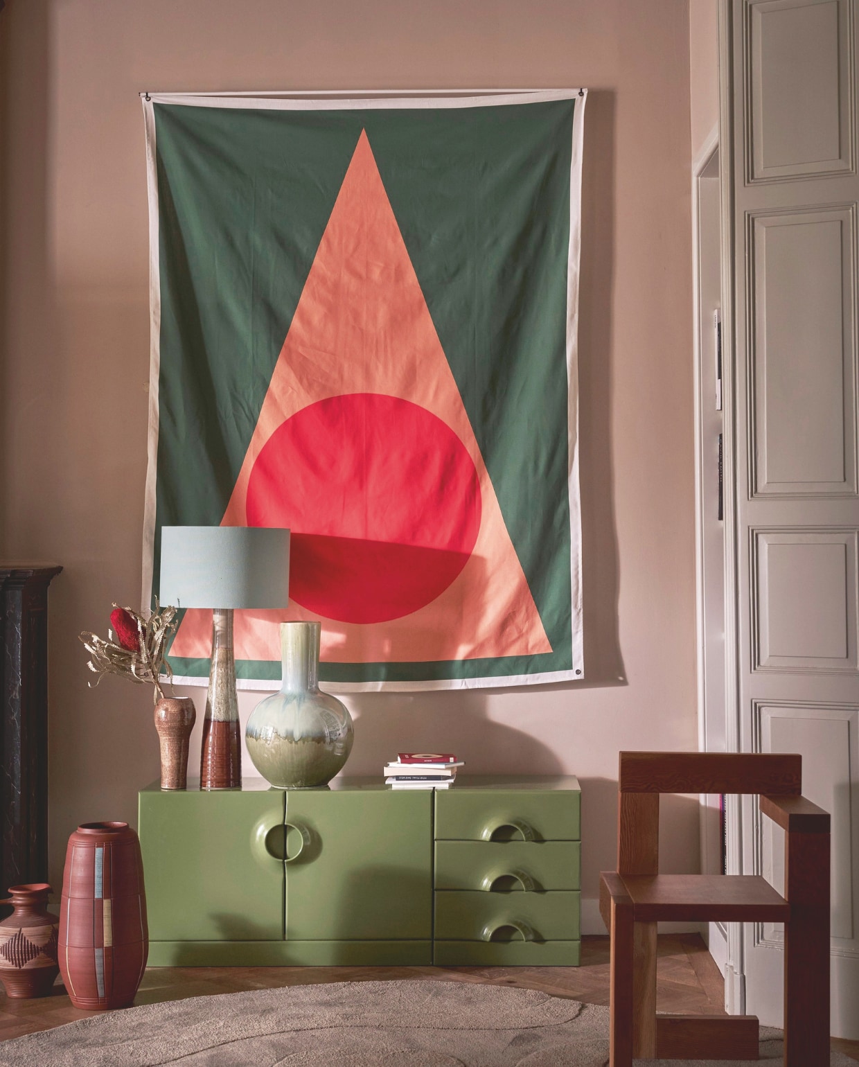 Wandkleed Metronome uit The Editions Collection van Gregory B, 140x195 cm € 160,- (gregorybstudio.com). Groen space age dressoir van Jürgen Lange voor Schönbuch, 53,5 cm (h) € 1695,- (bestwelhip.nl). Vloerkleed Alya van Woood, 170x240 cm € 359,-, vaas Holm van Mica Decorations (vtwonen.nl). Hoge terracotta vaas op de grond € 145,-, bolle vaas € 85,-, hoge smalle vaas exclusief kap € 90,- (redesignvintage.nl). Houten vintage Steltman stoel naar ontwerp van Rietveld, per twee € 1100,- (whoppah.com). Kleine vintage vaas € 50,- (studio-alloo.nl). Overig privébezit. vtwonen 11-2024 | styling Cleo Scheulderman | fotografie Jeroen van der Spek