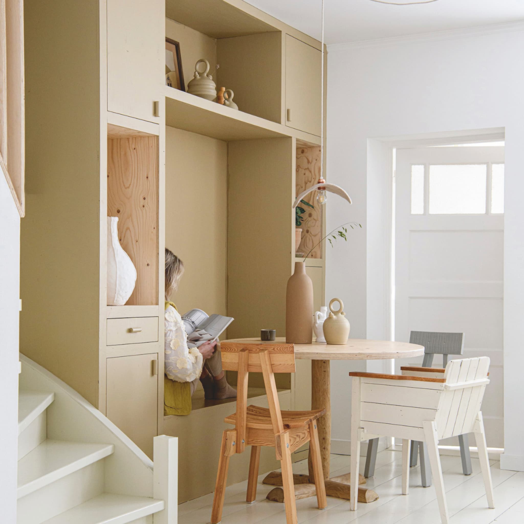 Handgemaakte kast met zitplek bij de ronde eettafel