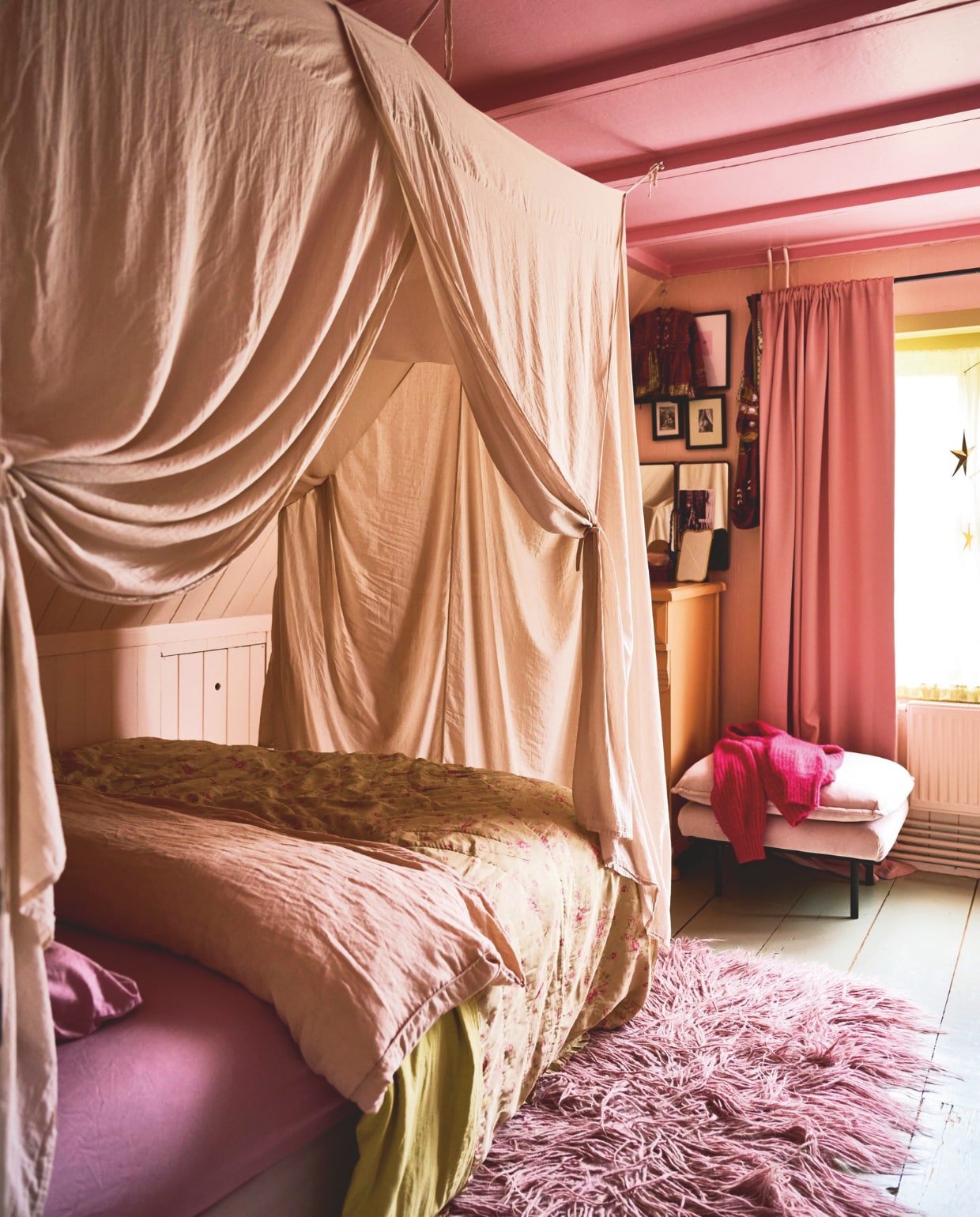 Muurkleur Pink Ground, plafondkleur Nancy’s Blushes van Farrow &amp; Ball, hemelbed Numero 74, hoeslaken en kussenslopen van Selected Femme, overtrek H&amp;M, sprei Brechtje Olsthoorn, vloerkleed Ume Studio, kast vintage, gordijnen Kwantum, poef HKliving, spiegel Ikea. vtwonen 10-2024 | styling Liza Wassenaar | fotografie Sjoerd Eickmans