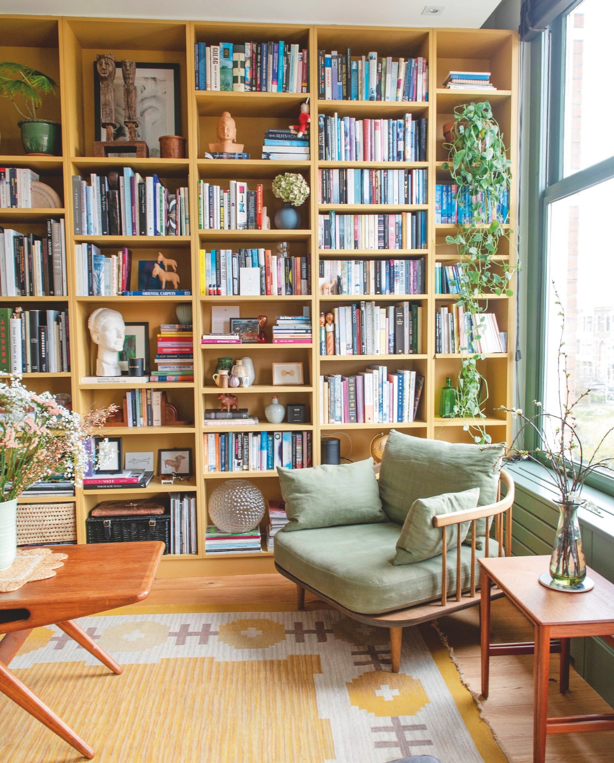 Boekenkast op maat gemaakt door timmerman, fauteuil Fly Chair SC1 &amp;Tradition, karpet We Are Here Now, vintage bijzettefel uit Denemarken, vintage vaas. vtwonen 11-2024 | stying Jeske Weel | fotografie Caroline Coehorst