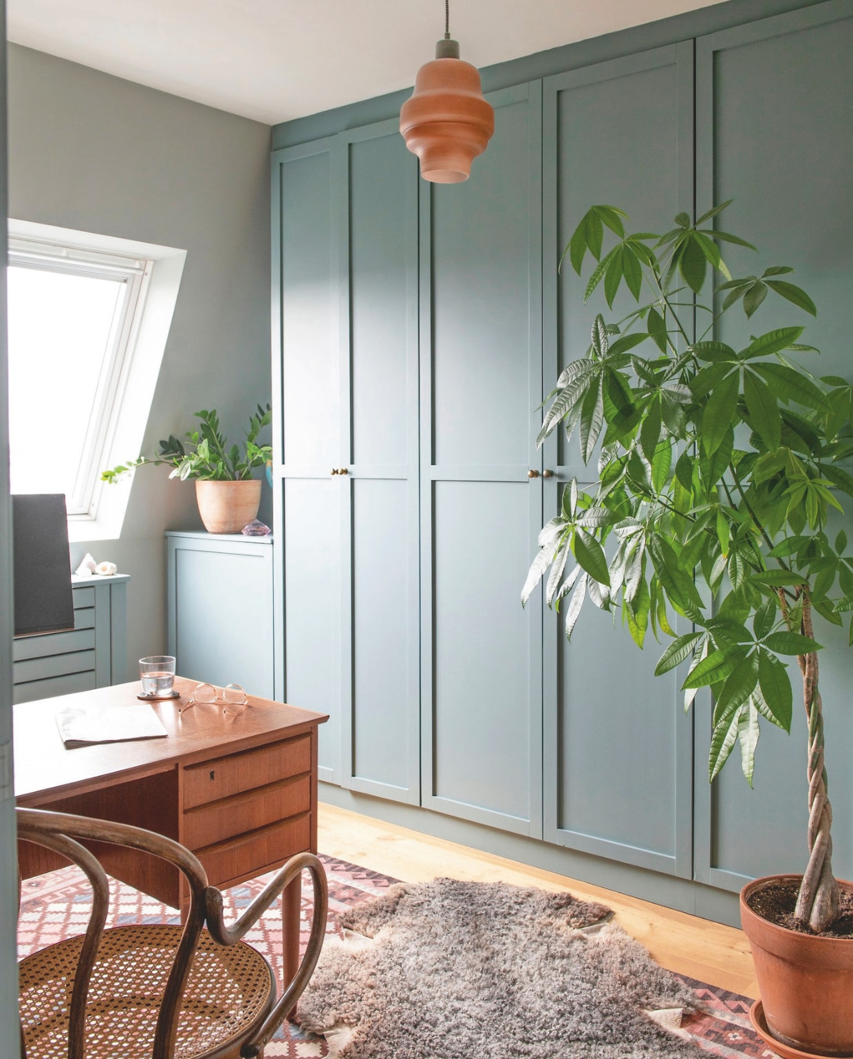 Vintage Thonet-stoel Marktplaats, vintage teakhouten bureau uit Kopenhagen, hanglamp Rein Living via Loods 5, wandkasten in kleur Light Blue van Farrow &amp; Ball, karpet We Are Here Now. vtwonen 11-2024 | stying Jeske Weel | fotografie Caroline Coehorst