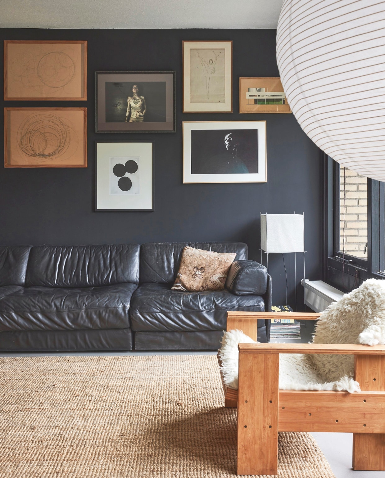 Bank vintage De Sede. Kelim kussen Yazgibi. Lamp Lotek van Benno Premsela. Stoel remake Kratstoel van Rietveld door Woodworks. Schapenvacht en kleed Ikea. Muurverf Balanced Black Wood &amp; Wall extra mat van Gamma. Radiator Rofix. Werk aan de muur: Kunstacademie cirkelstudies van Mies. Foto Alljan Moehamad. Drie stippen San Ming. Danseres maker onbekend. Zwart-wit foto Andy Tan. Villa Savoye, Le Corbusier van Sander Patelski. vtwonen 11-2024 | styling fietje bruijn | fotografie alexander van berge