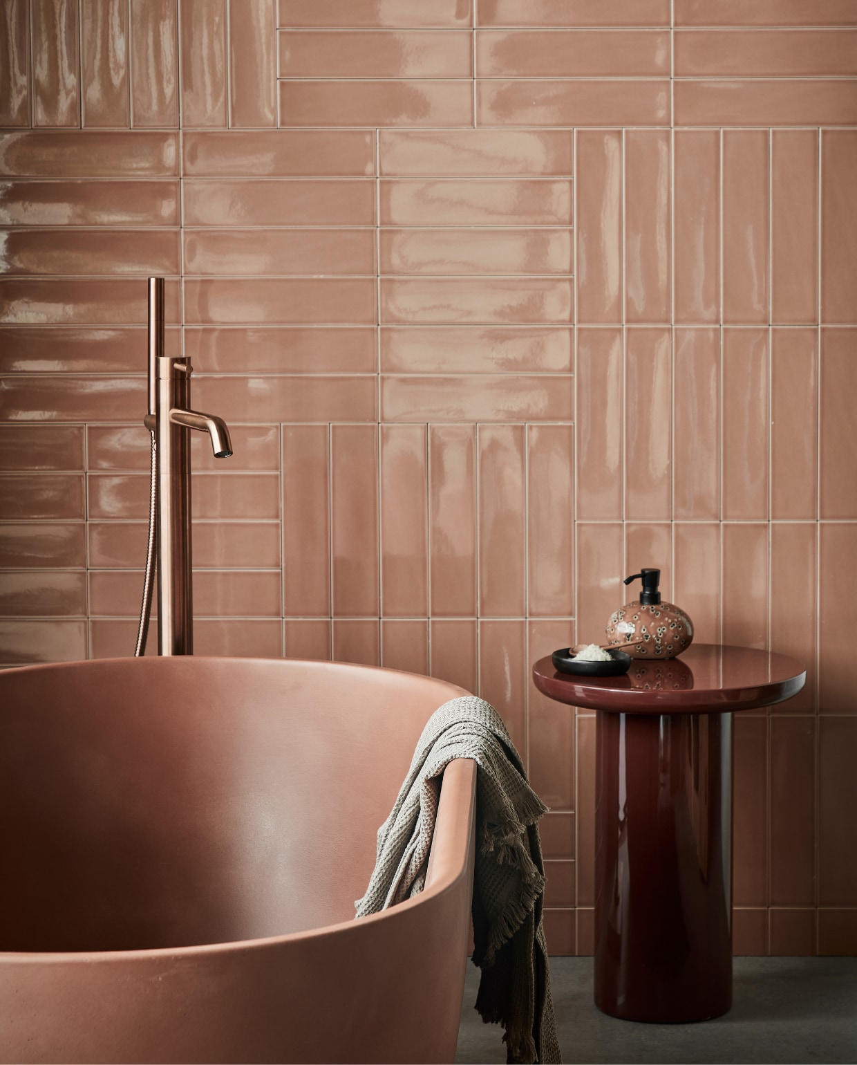vtwonen collectie vloeren en tegels, Vloertegels Raw Grey, 80x80 cm per m² € 79,95, wandtegels achter bad Shapes Toffee glans, 7,5x30 cm per m² € 58,99, detremmerie.be (bad), polspotten.com (bijzettafel Mob), vtwonen.nl (badmat van Ferm Living, marmeren schaal en zeepdispenser Ugo van Aquanova), Uit de vtwonen badkamercollectie: vrijstaande badkraan Roma van Plieger. Overig privébezit. vtwonen 02-2023 |  styling Sanne Ketelaar | fotografie Peggy Janssen