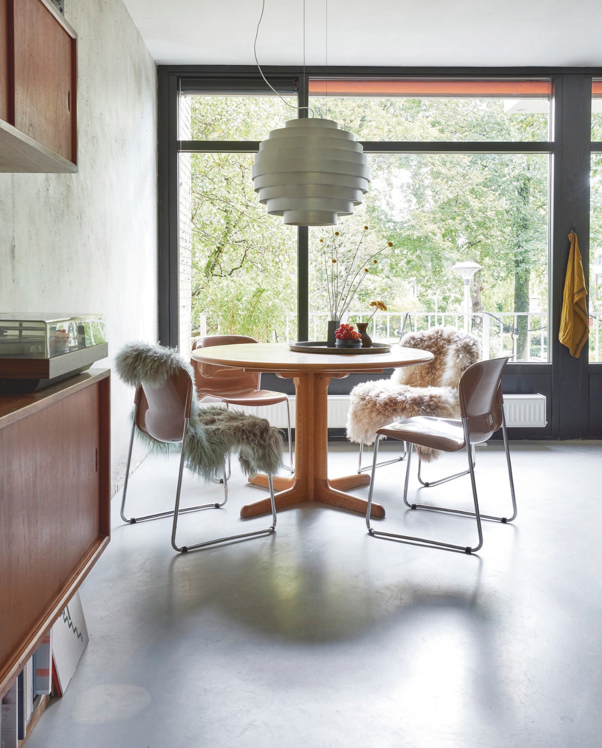 Tafel vintage jaren 60 Gudme. Stoelen Swing Chair van Gerd Lange. Schapenvachten Pure Markt. Vintage lamp van Theo & Silvia Sogni voor Antonangeli. Betonlook gietvloer  Knulst Vloeren. vtwonen 11-2024 | styling Fietje Bruijn | fotografie Alexander van Berge