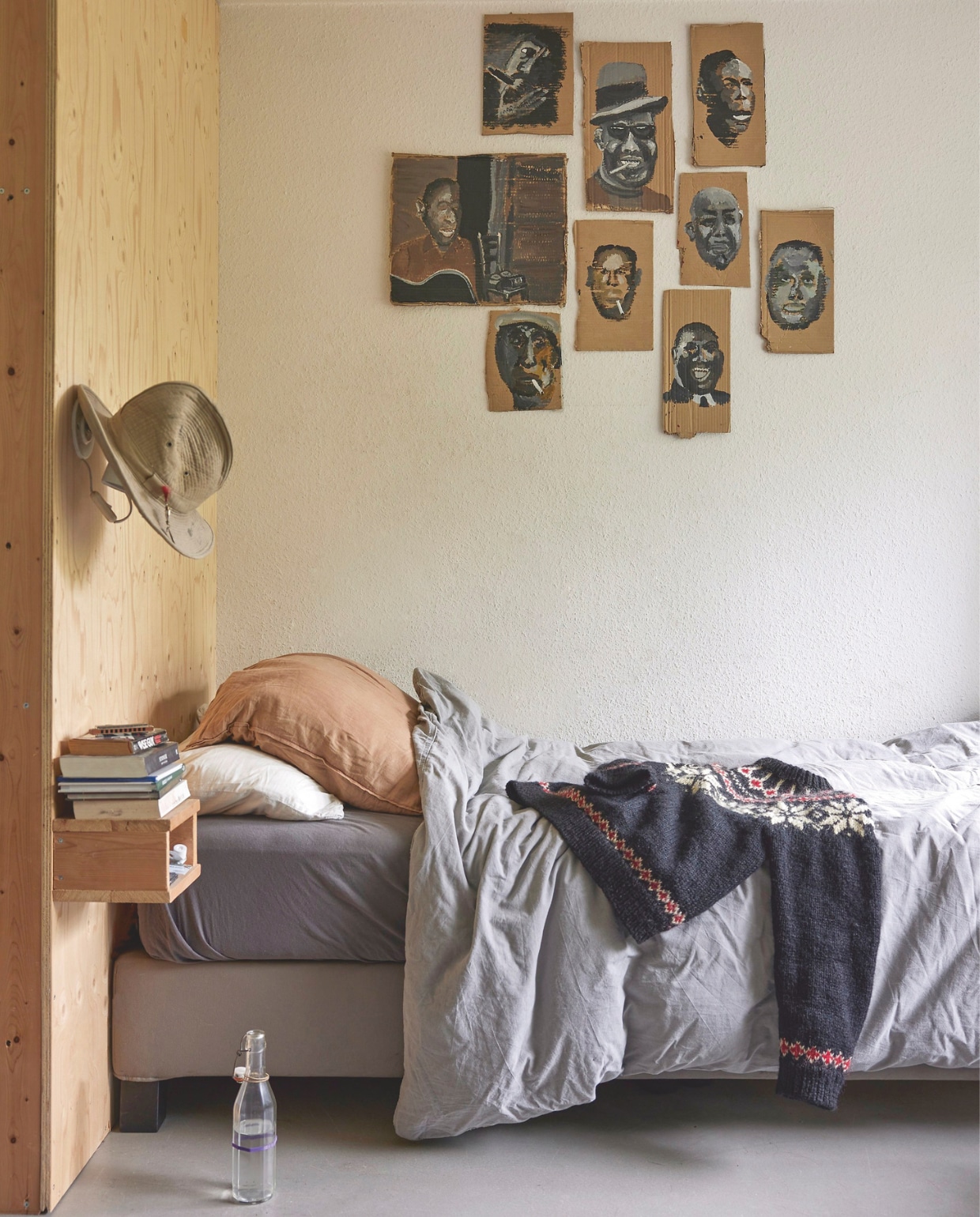 Portretten van bluesartiesten door Piet. Hoed vintage French Army Bush Hat. Houten underlayment wand en nachtkastje eigen ontwerp. Bed Ikea. Beddengoed Hema. Kussensloop Suite702. vtwonen 11-2024 | styling Fietje Bruijn | fotografie Alexander van Berge