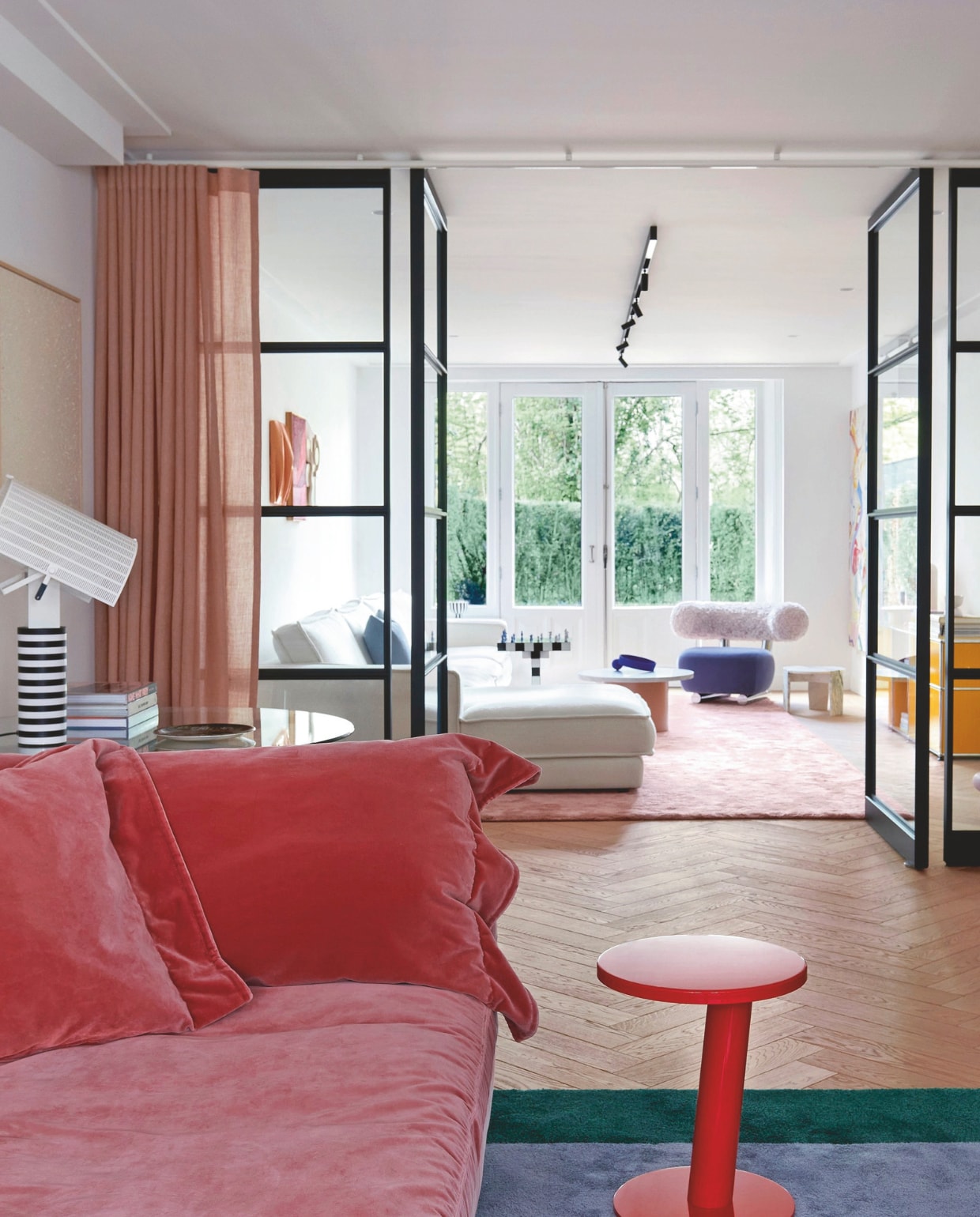 Zwarte taatsdeuren scheiden detv-kamer van de zithoek. Bank Nebula Nine en bijzettafel Pipe van Moroso, tafellamp Shogun van Artemide. Het vloerkleed liet Sallyop maat ontwerpen in Portugal. stijlvol wonen 07-2024 | styling Barbara Berends | fotografie Kasia Gatkowska