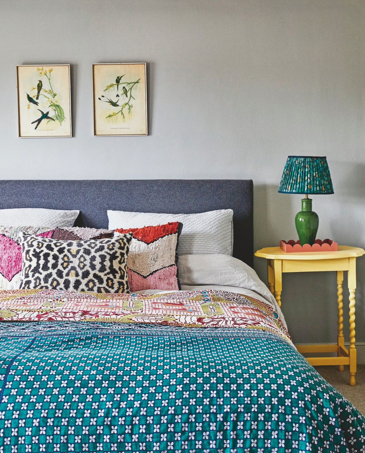 Prints vintage, muurverf Lamp Room Grey van Farrow & Ball, luipaardkussen Punica, groot kussen van Edit 58, bijzettafel en lampvoet vintage, lampenkap Emily Rose studio, sprei van vintage Afrikaanse stoffen. vtwonen 11-2024 | styling Kay Prestney | fotografie Brent Darby