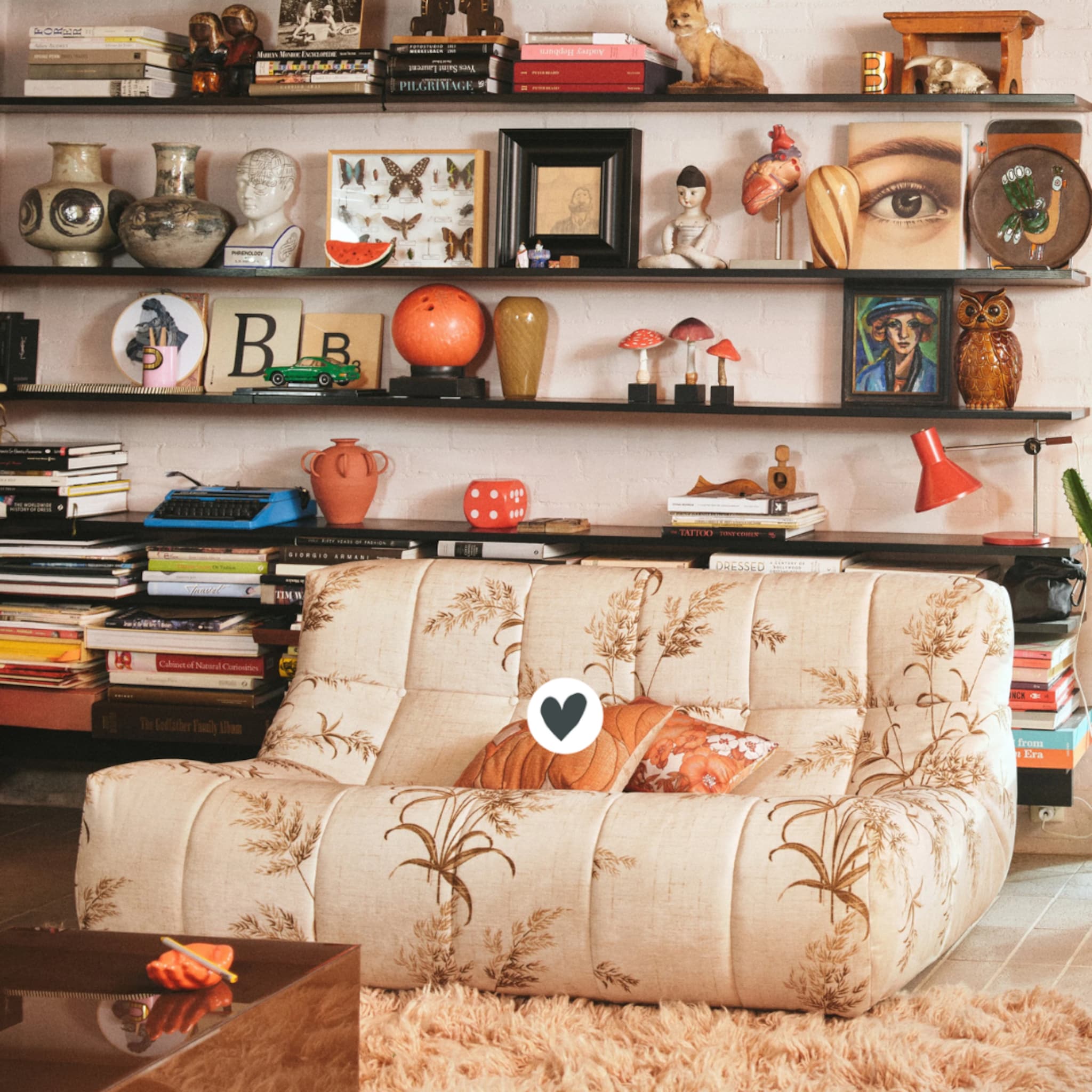 Retro interieur met een boekenkast vol accessoires en een fauteuil met print
