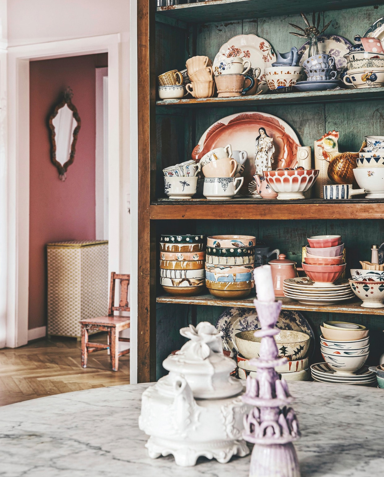 Servieskast, stoel, spiegel en ronde tafel vintage. Maria heeft het servies door de jaren heen verzameld. vtwonen 11-2024 | styling Lina Vertus | fotografie Isabell Wedin