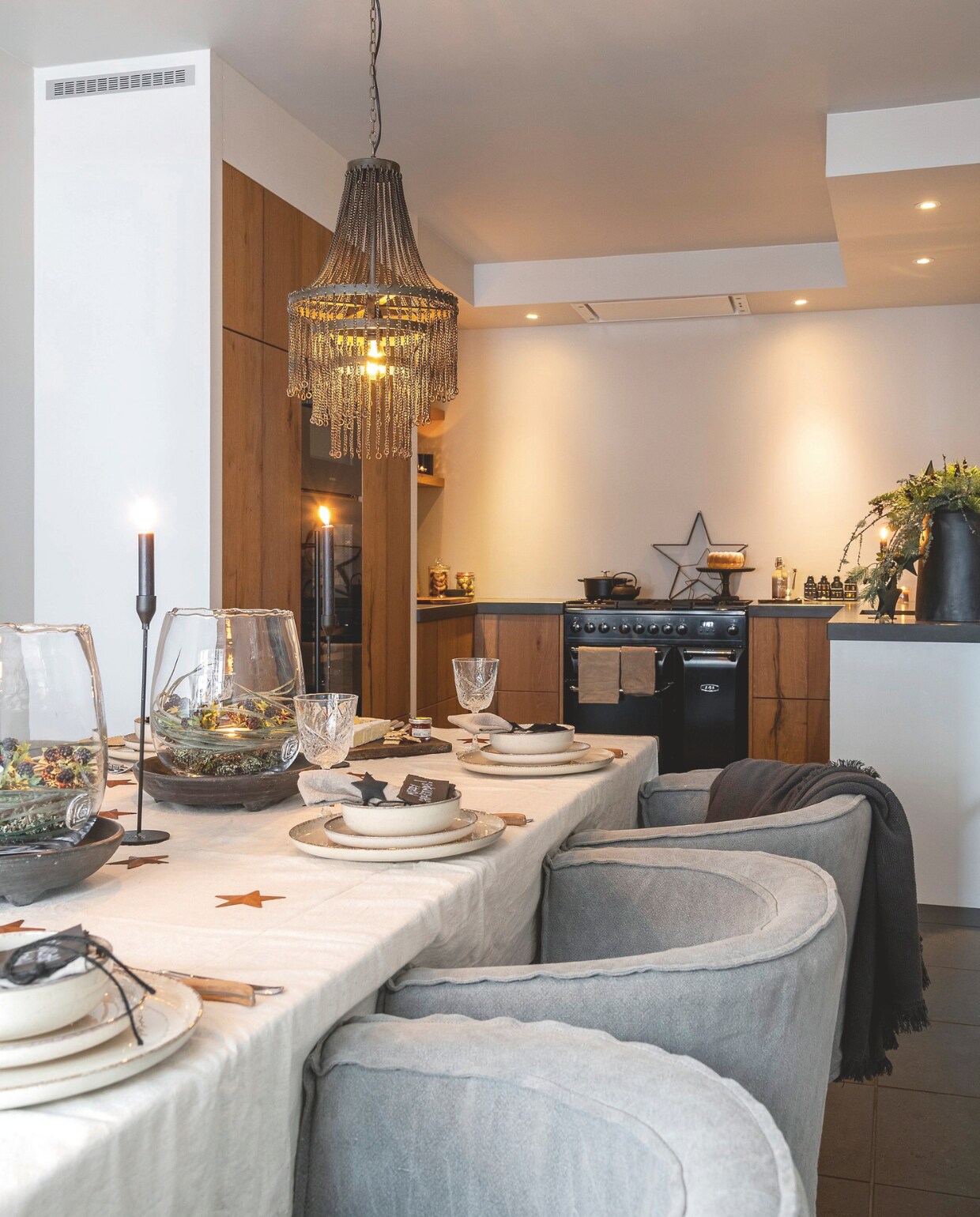 In de volledig gerenoveerde keuken speelt gewassen linnen de hoofdrol, zowel in het tafellinnen van Zara Home als op de stoelen van Aura Peeperkorn. De windlichten zijn van Gommaire en komen van Het Hoogehuys in Kessenich. vtwonen landelijk 07-2024 | fotografie Jonah Samyn