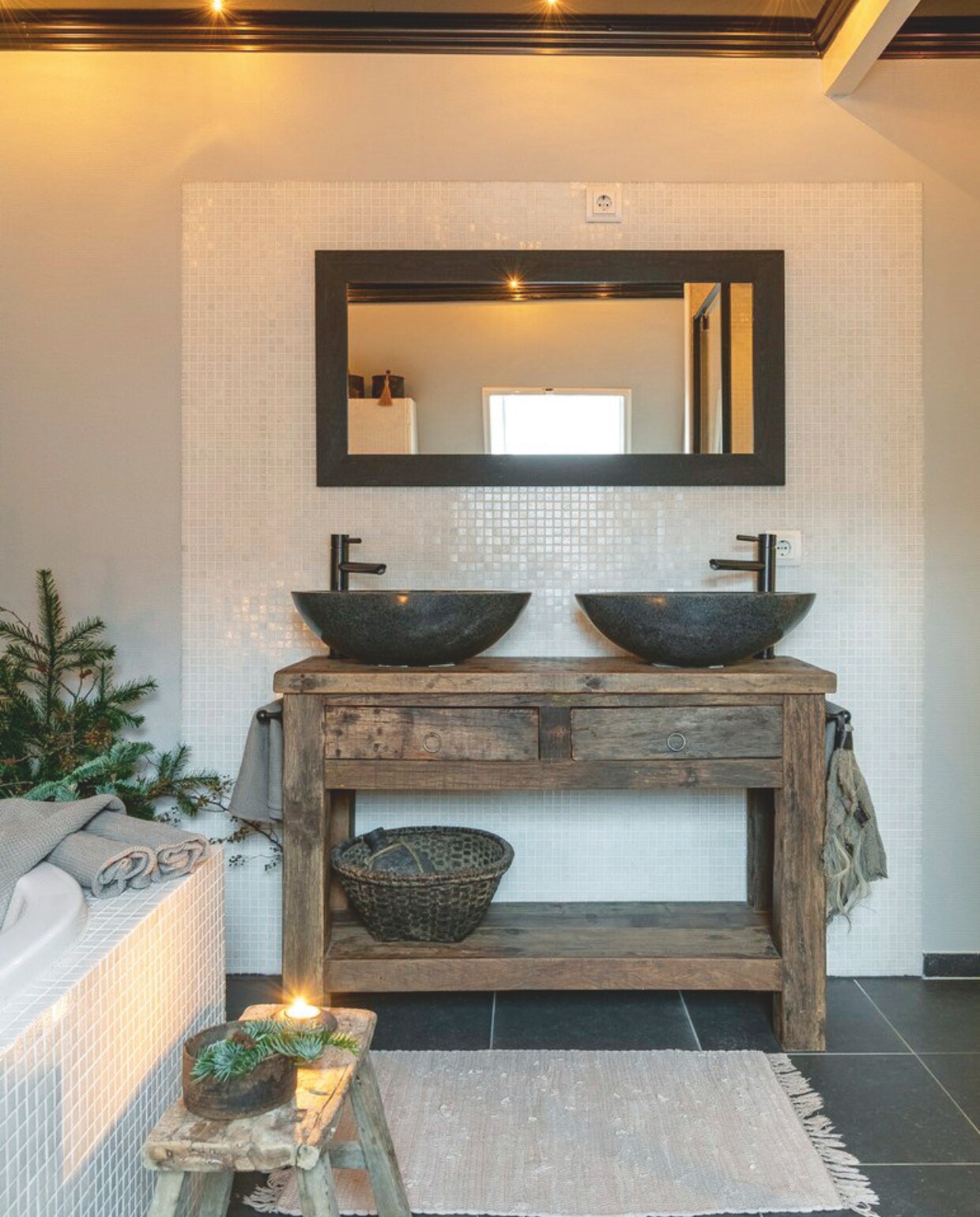 In de badkamer koos Sharona voor een oud houten wastafelmeubel en zwarte kranen, om de ruimte wat intiemer te laten aanvoelen. vtwonen landelijk 07-2024 | fotografie Jonah Samyn