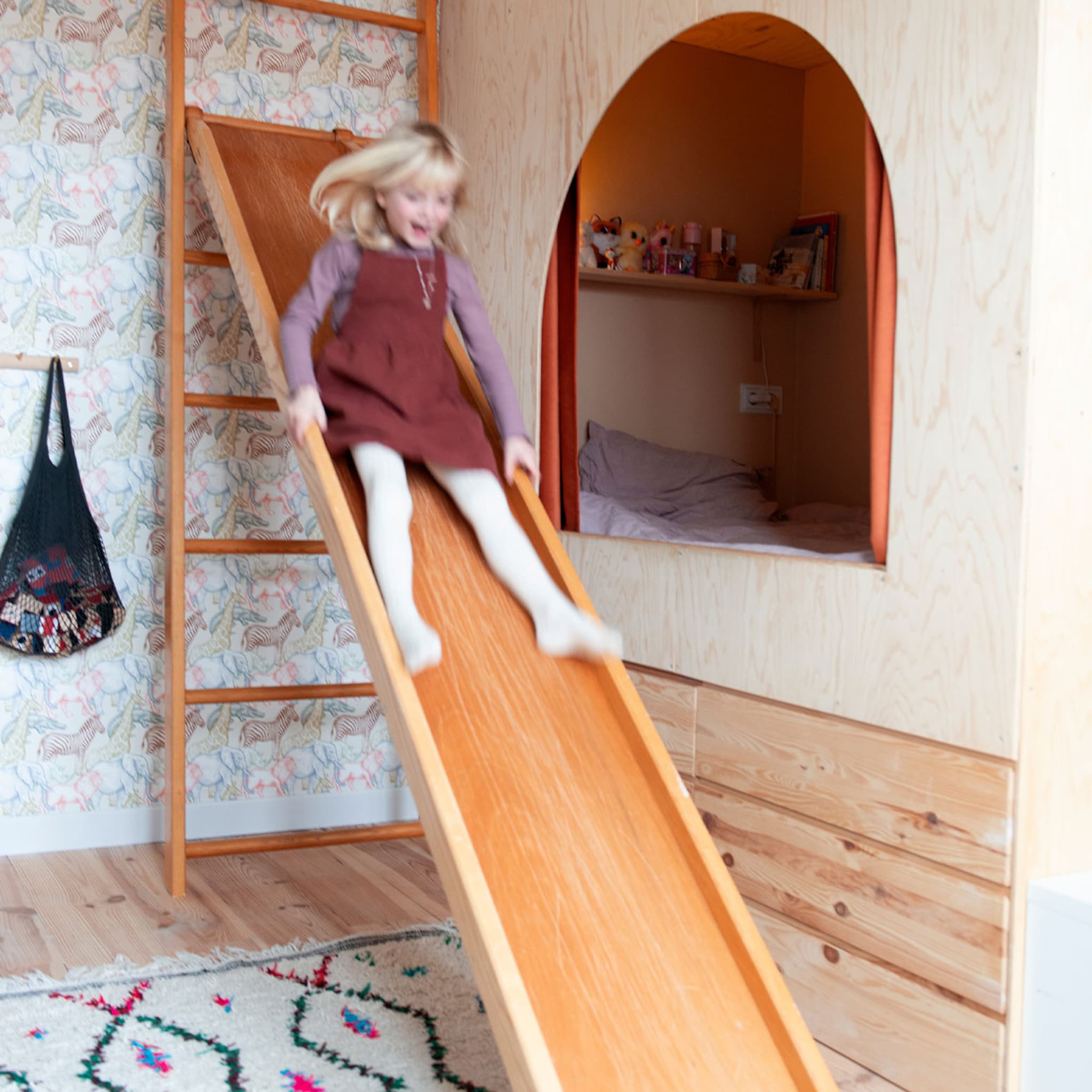Kinderkamer met een zelfgemaakt bed en speelse glijbaan