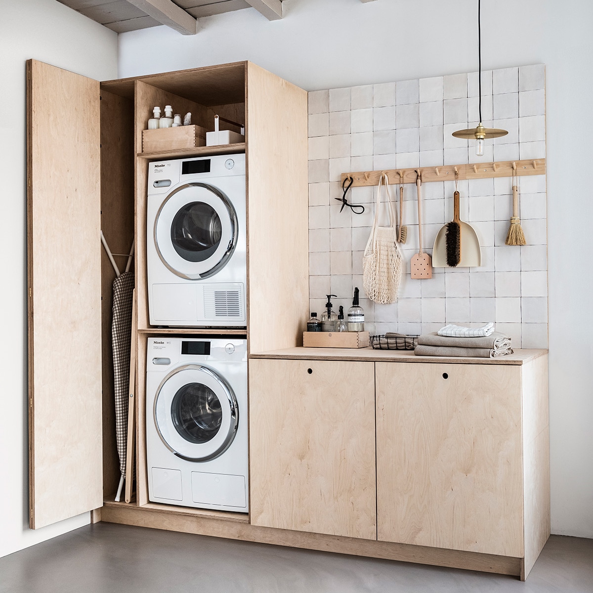 Uitgelicht beeld - Strijkplank Ruter, strijkplankhoes Lagt, witte handdoeken Saliken Ikea. Houten wasrek, berkenhouten vierkante opbergbox, witte toolbox large, berkenhouten rek met 7 haken, berkenhouten rek met 4 haken, schaar, afwasborstel, stoffer en blik, berkenhouten opbergbox smal, knitted handdoeken Iris Hantverk. Wasmachine WWR760 WPS PWash 2,0 &amp; TDos XL &amp; Wifi, met automatisch doseringssysteem en quick power wash en ook WiFiconnect, droger TWER860 WP Eco&amp;Steam Wifi&amp;XL met WiFiconnect Miele. Wasmiddel, hanglamp FrmaCircle Shade, leren vliegenmepper by Molle. Nettas natural, zwart draadmandje the Fine Store. Lichtgrijze wasmanden Laundry L van Hay, tegels Craft Egg white mat van vtwonen. Theedoek met ruit H&amp;M Home. Overig privbezit. vtwonen 04-2019 | productie &amp; styling Kim van Rossenberg | uitvoering Richard van Meerveld | fotograaf Sjoerd Eickmans