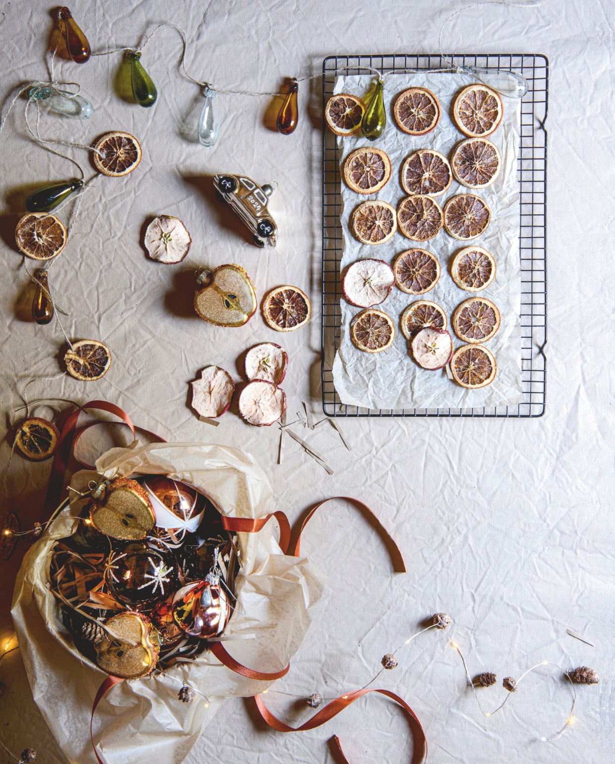 Canvas ondergrond, vanaf A4-formaat € 16,95 (mo-ca.nl). Gerecycled glazen druppelornamenten € 43,58 (livinginharmony.uk). Glazen appel van House of Seasons € 4,- (vtwonen.nl/shop). Glazen auto van House Doctor € 13,49 (connox.nl). Bruine glazen bal Ster van House Doctor, set van 4 € 24,49, gestreepte bal van House Doctor, set van 4 € 21,95 (connox.nl). Verlichtingsnoer met dennenappels, 2 meter € 14,95 (sirius.dk). vtwonen 12-2024 | styling Marit Saladini | fotografie Louis Lemaire