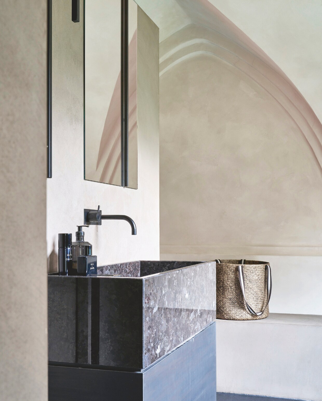 Wastafel gemaakt van gepolijst natuursteen op een ijzeren basis, kraan van Vola. stijlvol wonen 07-2024 | Productie Living Inside | styling en tekst Francesca Davoli | Fotografie Fabrizio Cicconi