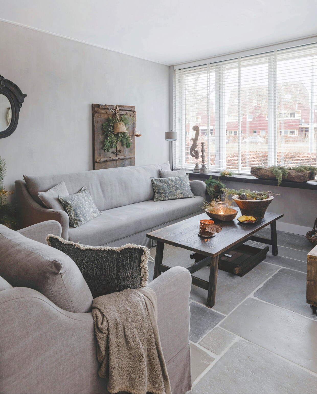 Bank en fauteuil van Rust &amp; tiek. De houten deur tegen de muur is van De Korenbloem Landelijk &amp; Sober Wonen, de bel en het windlicht van Met Landelijk Label. vtwonen landelijk 07-2024 | Styling Rust &amp; tiek | Fotografie Corine Hoge Bavel-Jansen
