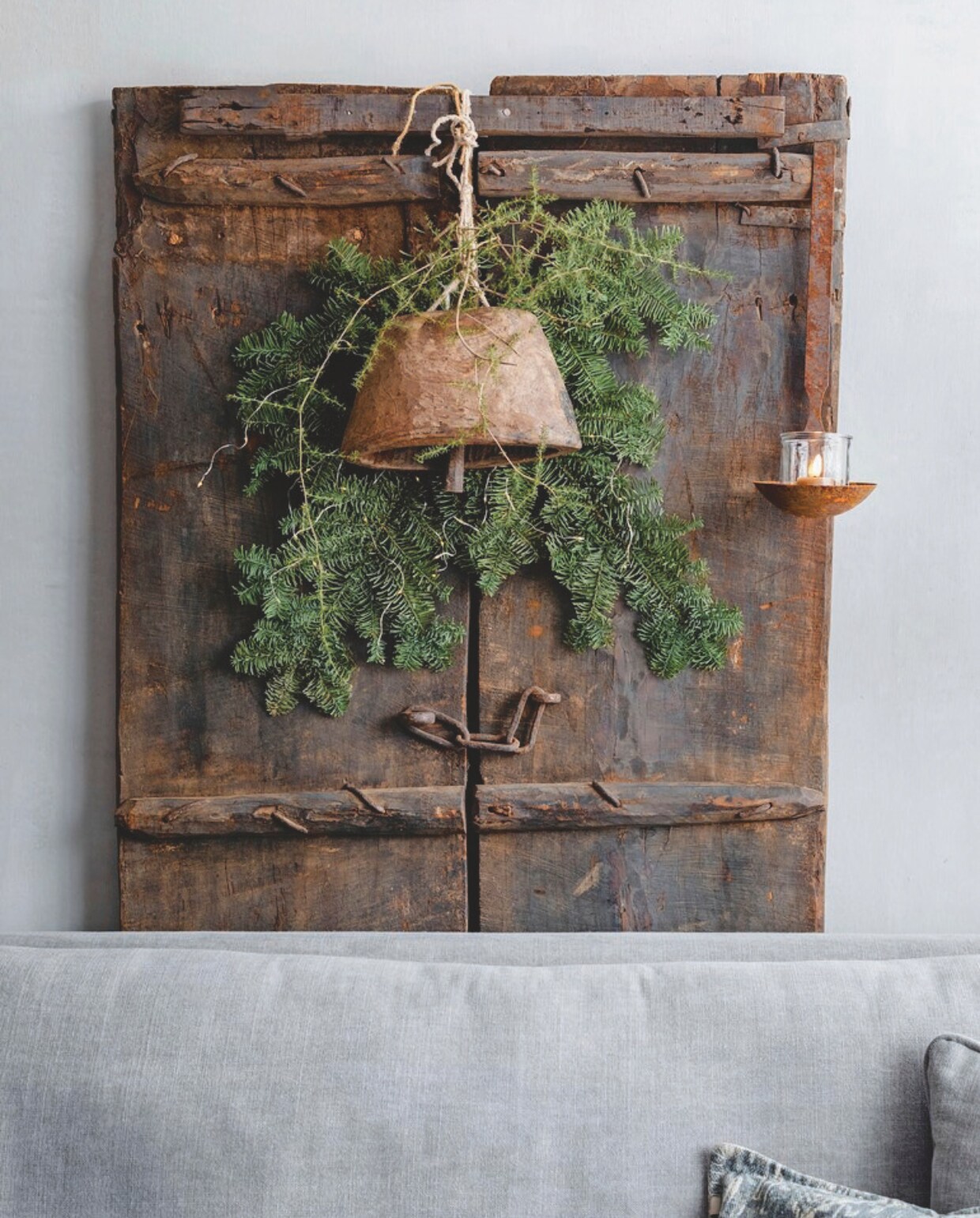 De houten deur tegen de muur is van De Korenbloem Landelijk &amp; Sober Wonen, de bel en het windlicht van Met Landelijk Label. vtwonen landelijk 07-2024 | Styling Rust &amp; tiek | Fotografie Corine Hoge Bavel-Jansen