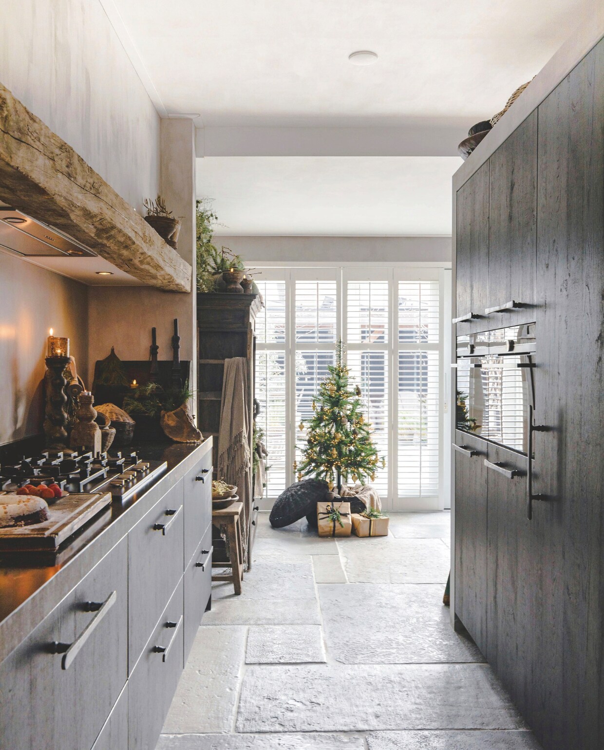 Doorkijkje vanuit de keuken naar de nieuwe uitbouw, waar de eetkamer zit. Kerstboom van Intratuin, decoraties in de boom van Rust &amp; tiek. Shutters van Veneta. vtwonen landelijk 07-2024 | Styling Rust &amp; tiek | Fotografie Corine Hoge Bavel-Jansen