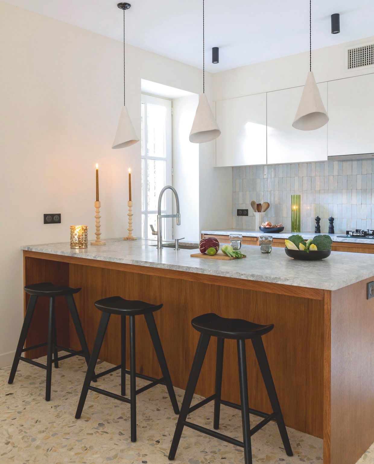 Keuken van gebeitst eiken met Super White Calacatta-marmer eigen ontwerp. Tegels Bejmat in kleur P1 Art et Sud Déco, kraan Laos van Imex, lampen gemaakt door Delphines zus, krukken Aline. vtwonen 12-2024 | styling Marie-Maud Levron | fotografie Cecile Perrinet-Lhermitt