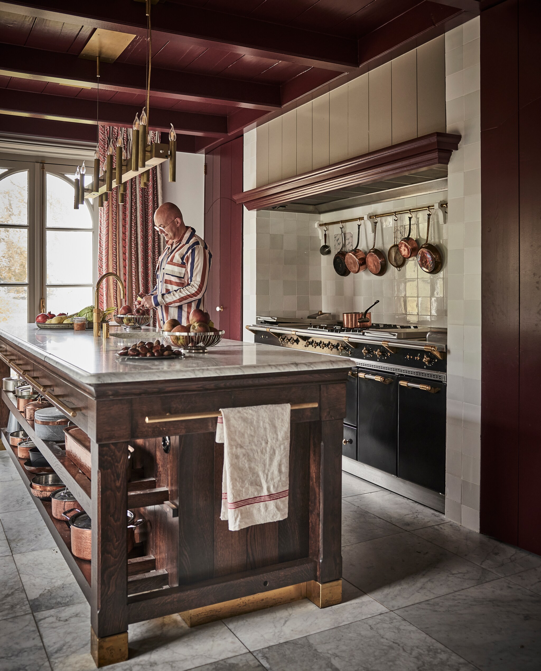 Keukenblok gemaakt door Hans Tinga. Lamp Brand van Egmond. Gordijnen Woodbridge Nina Campbell. Kraan Quooker. Fornuis Lacanche. Theedoek van19de-eeuws Frans linnen van veiling. Koperen pannen van over de hele wereld. Witjes Het Friese Tegelboertje. Marmeren tegels Amata Carrara. Kleur houtwerk Persiaans rood Vettewinkel. vtwonen landelijk 01-2025 | styling Marianne Luning | fotografie Alexander van Berg | tekst Merel van der Lande