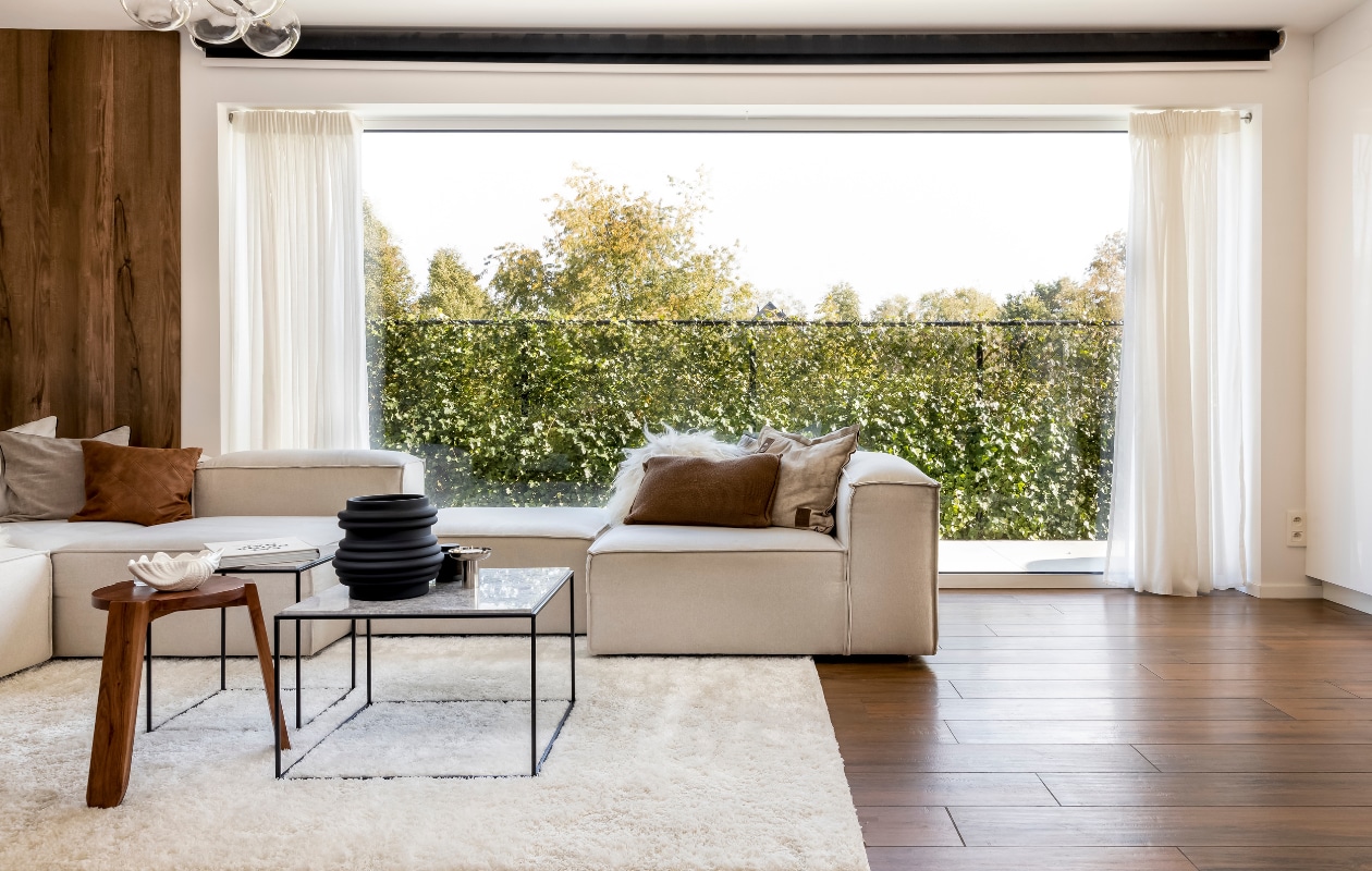 Tv-meubel, kast, dozen en gordijnen Ikea. Wandschap Woud. Schelpvormige schalen Loods 5, zwarte vazen en kandelaars Jysk en H&amp;M Home. Vierkante tafels Kwantum, houten kruk H&amp;M Home. Modulebank en lichte kussens Westwing, bruine kussens Kwantum. Kleed Tapeso. Lamp in zithoek Atmooz, lamp in leeshoek Lampen24. Witte vaas Jysk. Houten wandpanelen Maestro. Zonwerend rolscherm Sun Invest. Overig onbekend. vtwonen 5-2022 | styling Niki Vanhoof fotografie Henny van Belkom | Tekst Christine van der Hoff