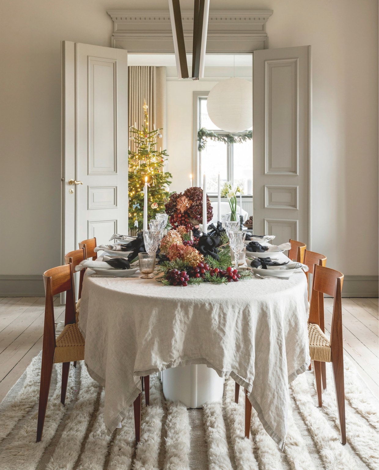 Linnen tafelkleed Nordal, zilveren borden Boho Habits, aardewerk Royal Copenhagen en rommelmarktvondsten, glaswerk vintage, servetten Broste Copenhagen, lamp Rubn, stoelen Pia van Poul Cadovius door DK3 Furniture, tapijt Jotex, stalen kunstwerk Kristian Jon Larsen. vtwonen 12-2024 | styling Rikke Graff Juel | fotografie Christina Kayser Onsgaard