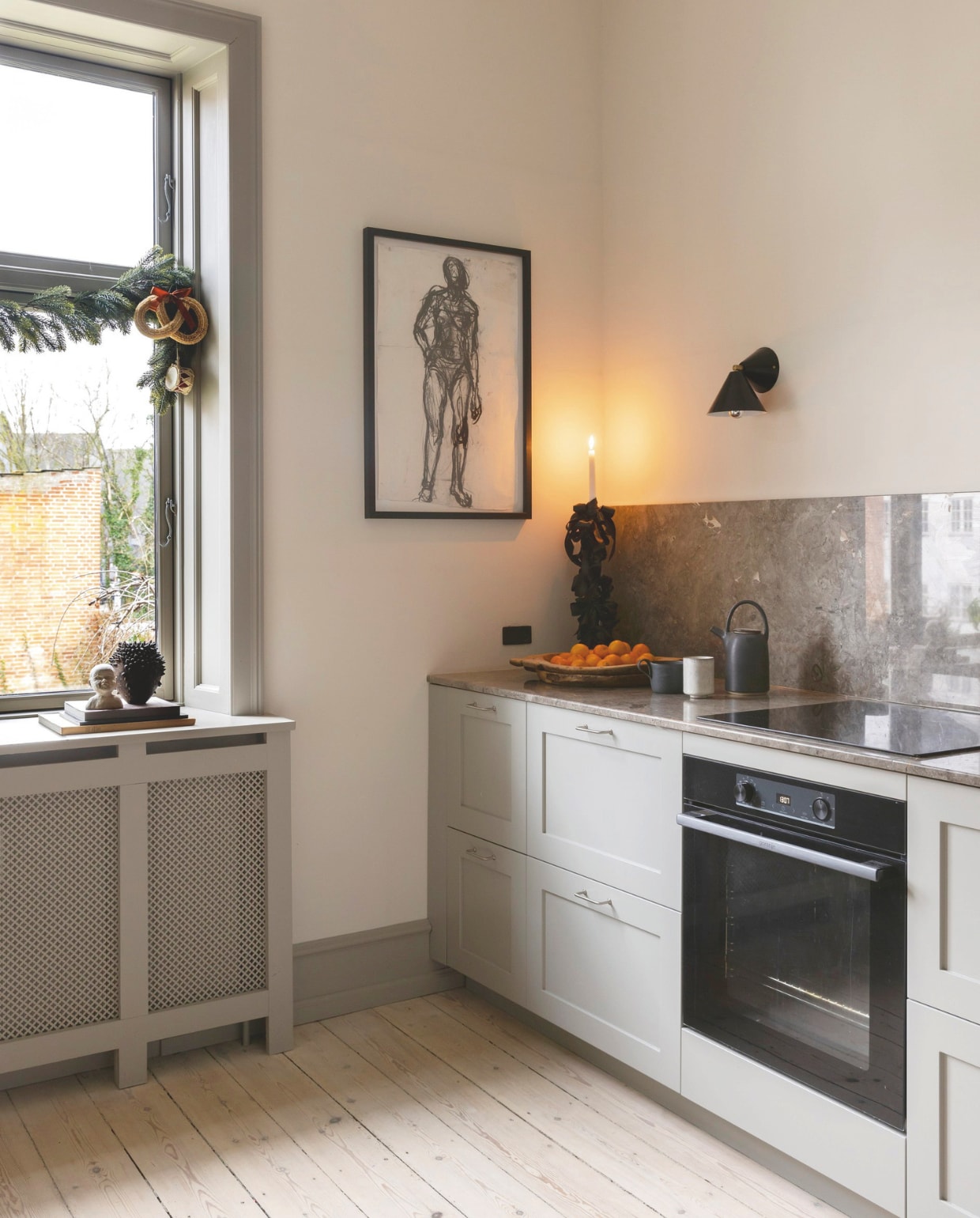 Keuken van inmiddels opgeheven Zweedse firma, blad grijsbruin marmer Grigio Bellini, kraan en spoelbak Grohe, lampen Atelier Areti, muren behandeld met silicaatverf kleur 9317 van Keim, glazen vaas Studio Oliver Gustav, houtskooltekening door Christians zus, kopjes en theepot Gurli Elbækgaard. vtwonen 12-2024 | styling rikke graff juel | fotografie christina kayser onsgaard