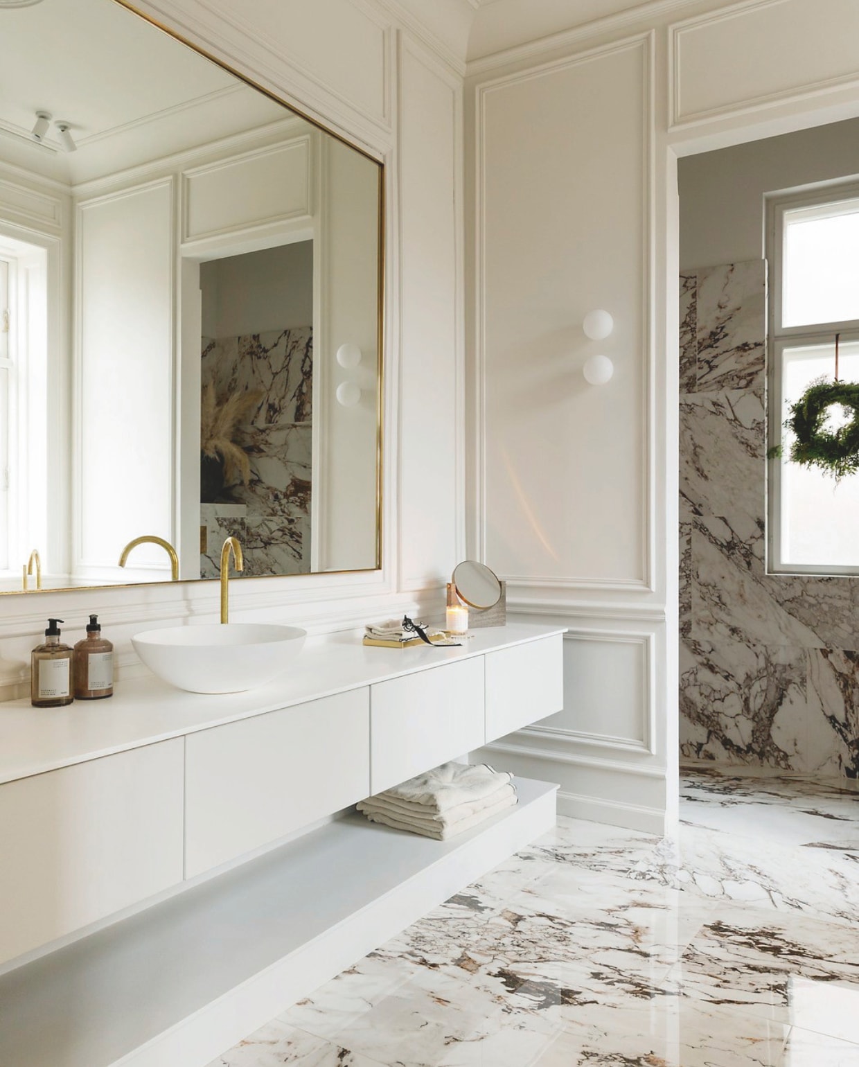Marmeren tegels Tile Universe, krans zelfgemaakt met varens, sparrentakken en ander groen uit de tuin. vtwonen 12-2024 | styling rikke graff juel | fotografie christina kayser onsgaard