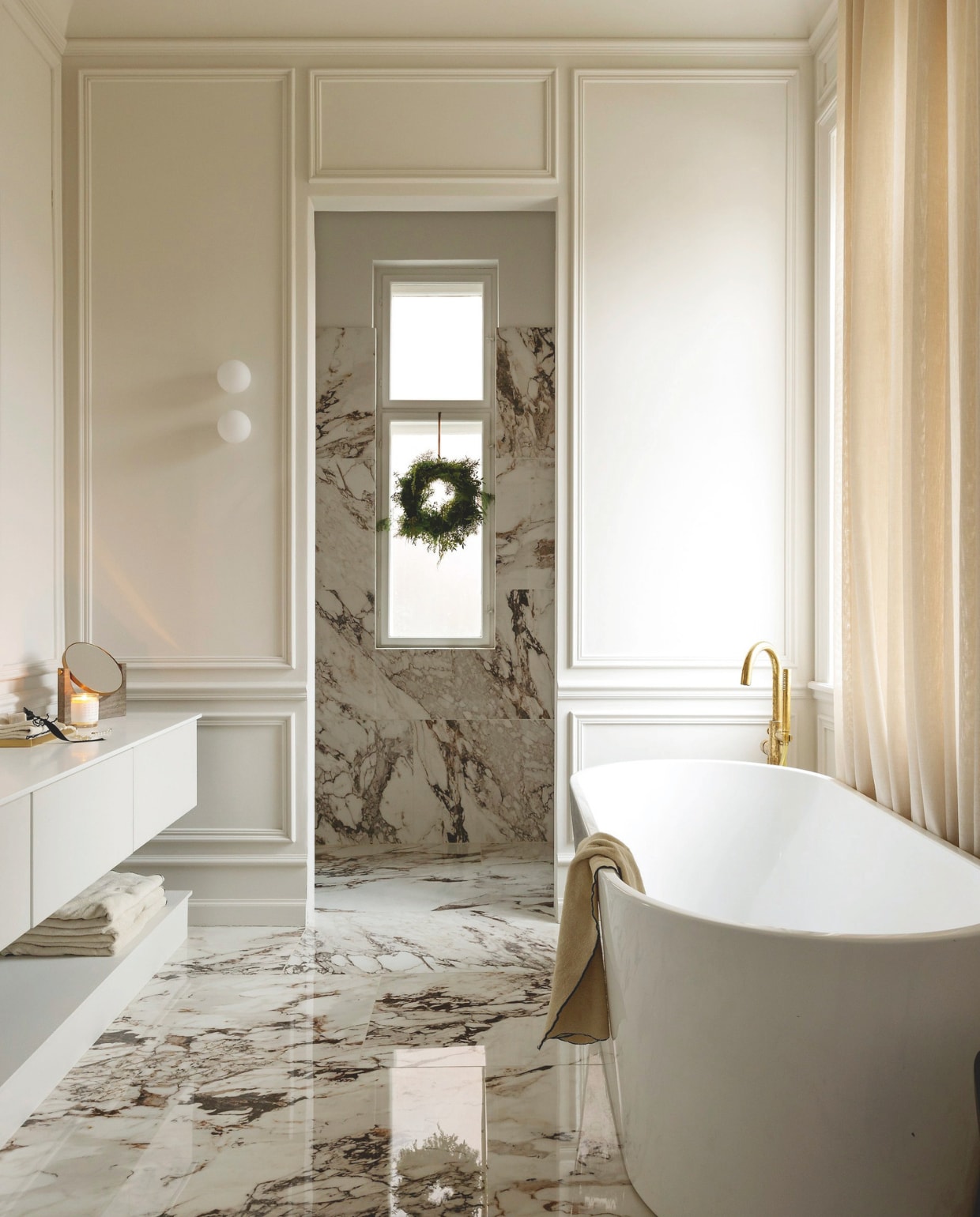 Marmeren tegels Tile Universe, handdoeken Zara Home, krans zelfgemaakt met varens, sparrentakken en ander groen uit de tuin. vtwonen 12-2024 | styling Rikke Graff Juel | fotografie Christina Kayser Onsgaard