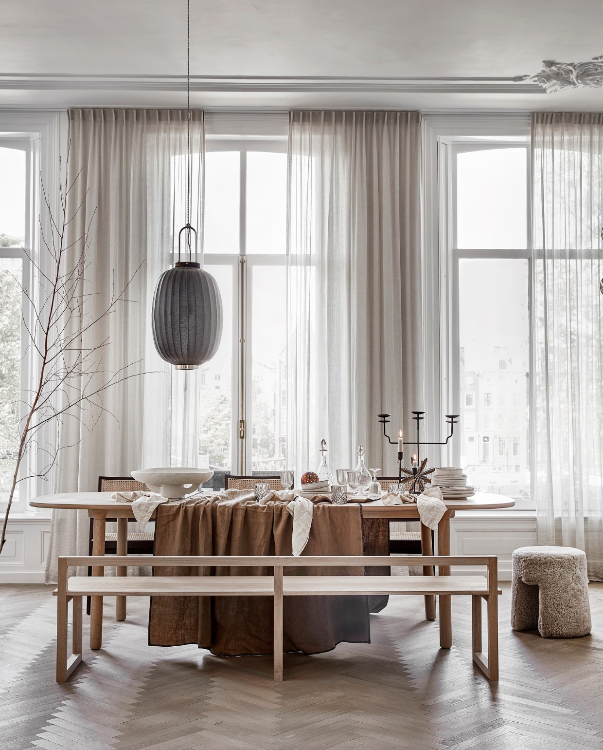 Lamswollen poef Sequioa van Frederica, 40 cm (Ø) € 1269,- (designtales.nl). Donkerbruine rotan eetkamerstoelen Pierre met armleuning, per stuk € 399,- (aimetestudio.com). Linnen tafelkleed Lola kleur Tabac, 170x300 cm € 132,95 (casagitane.com). Wijnglazen, per stuk € 3,99, drinkglazen, per stuk € 7,99, beige servies vanaf € 6,99, servetten, per 2 € 9,99 (zarahome.com). Dinerkaarsen ribbel, per stuk € 2,35 (bluryourlife.com). Zwarte lantaarn van Taiwan Lantern € 1150,- (entertheloft.com). Zwarte, drie-armige kandelaar € 57,95, zwarte kandelaar M € 18,25 L € 19,25, sneeuwvlokhanger € 15,50, handgemaakte koperkleurige kerstbol met stippen € 6,95 (weldaad.com). Witte papier-maché schaal Earth van Serax € 179,-, zwarte messing servetringen van Ferm Living, per 5 € 32,99 (vtwonen.nl). Oude glazen karaffen (kringloopwinkel). Gordijnen privébezit. vtwonen 12-2022 | styling Kim van Rossenberg | uitvoering Richard van Meerveld | fotografie Peggy Janssen