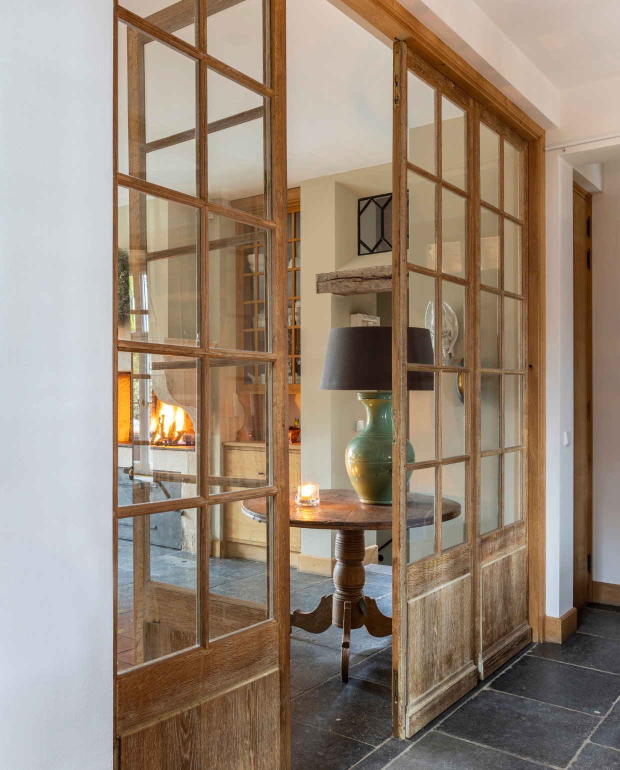 Oude eikendeuren met ruitjes en vloer van Belgisch hardstenen tegels van ’t Achterhuis. vtwonen landelijk 7-2024 | Fotografie Anneke Gambon